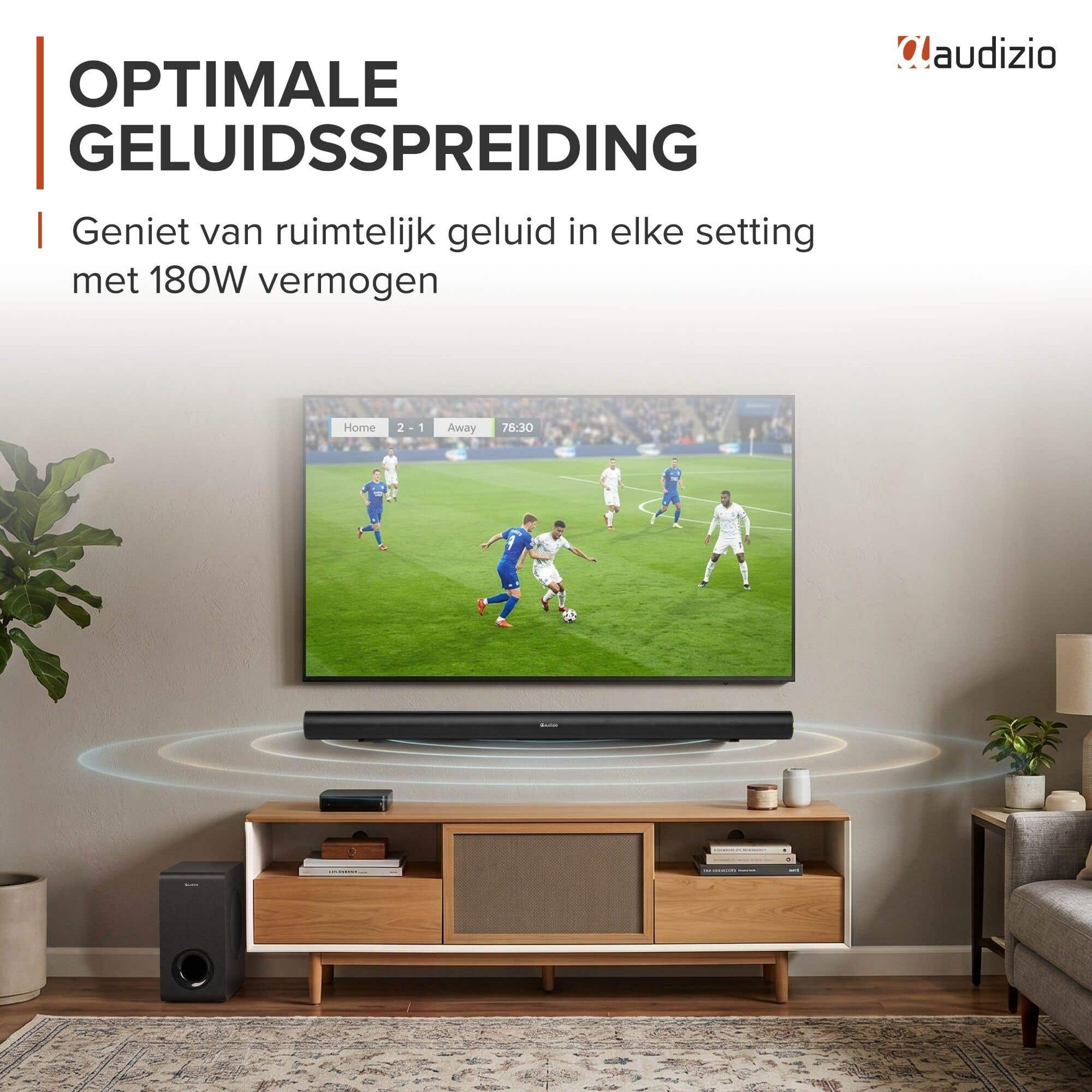 Un televisor con barra de sonido muestra un partido de fútbol. Un subwoofer está al lado.