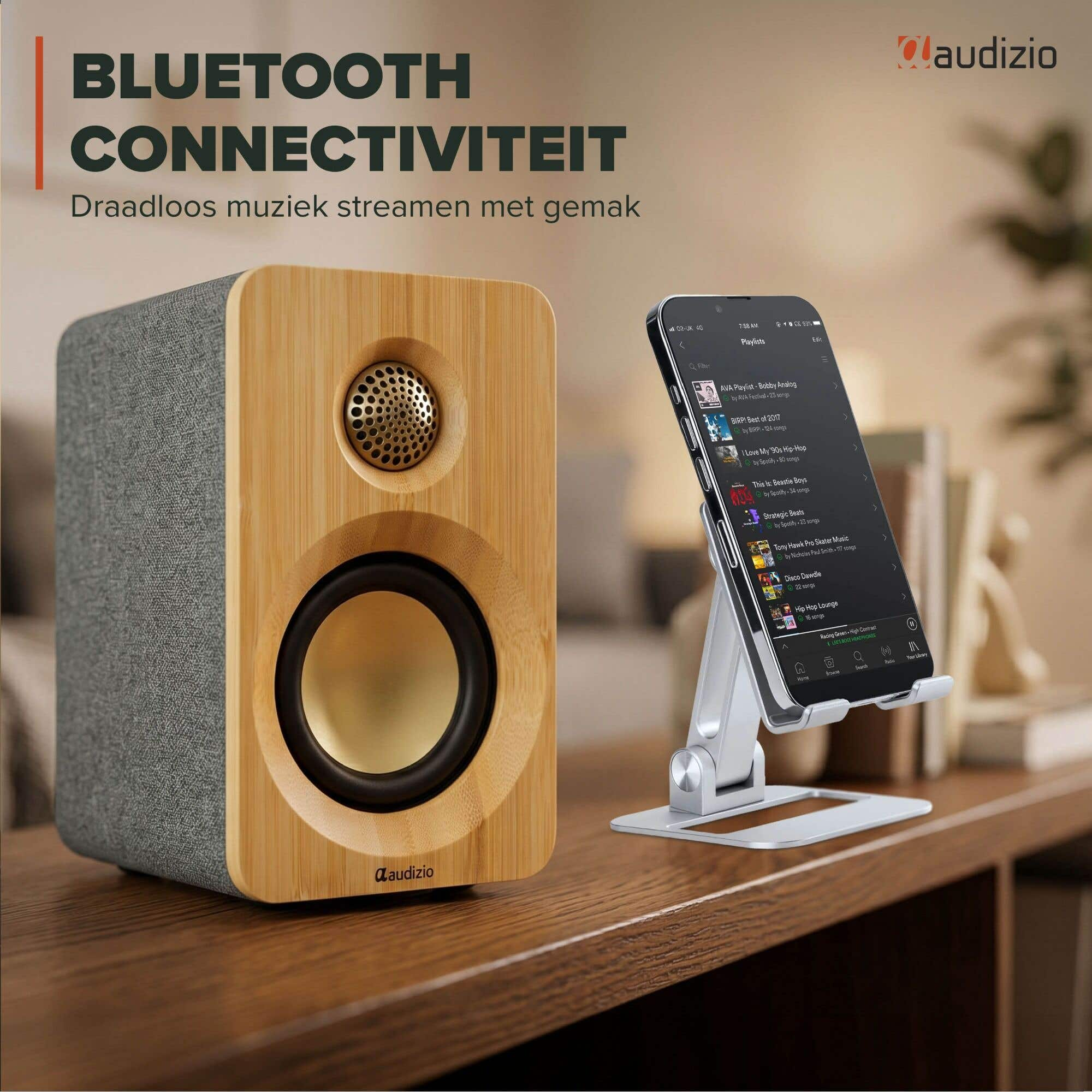 Altavoz de madera con lateral de tela junto a un smartphone con app de música.
