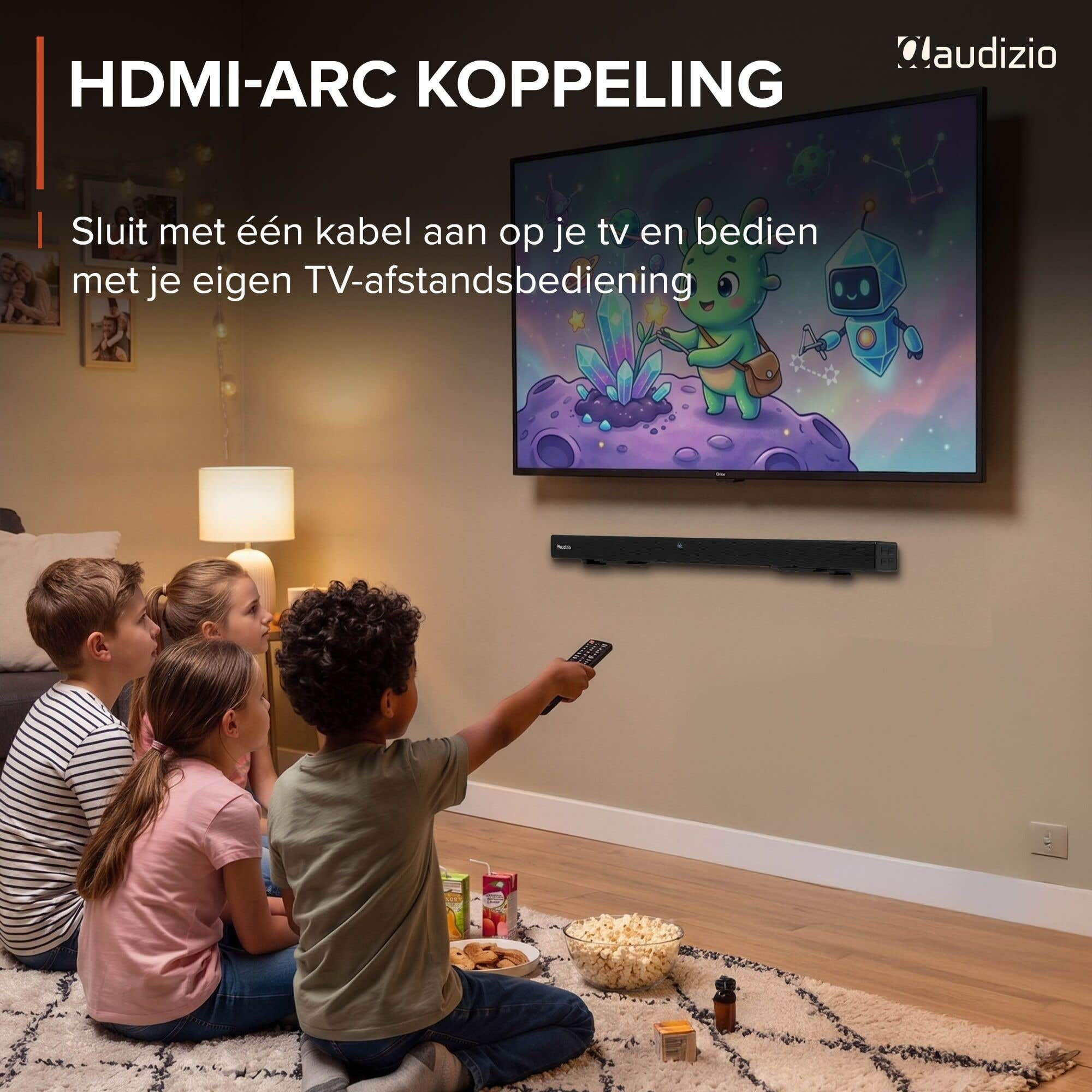 Cuatro niños sentados en una alfombra viendo la tele. Una barra de sonido cuelga debajo del televisor.