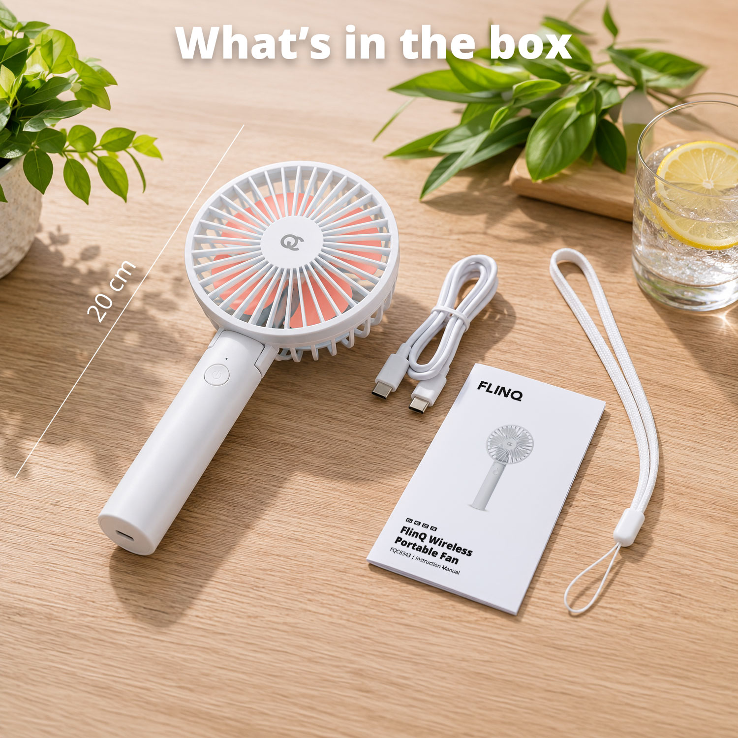 Ein weißer tragbarer FlinQ-Ventilator mit orangefarbenen Lamellen, Ladekabel und Anleitung.