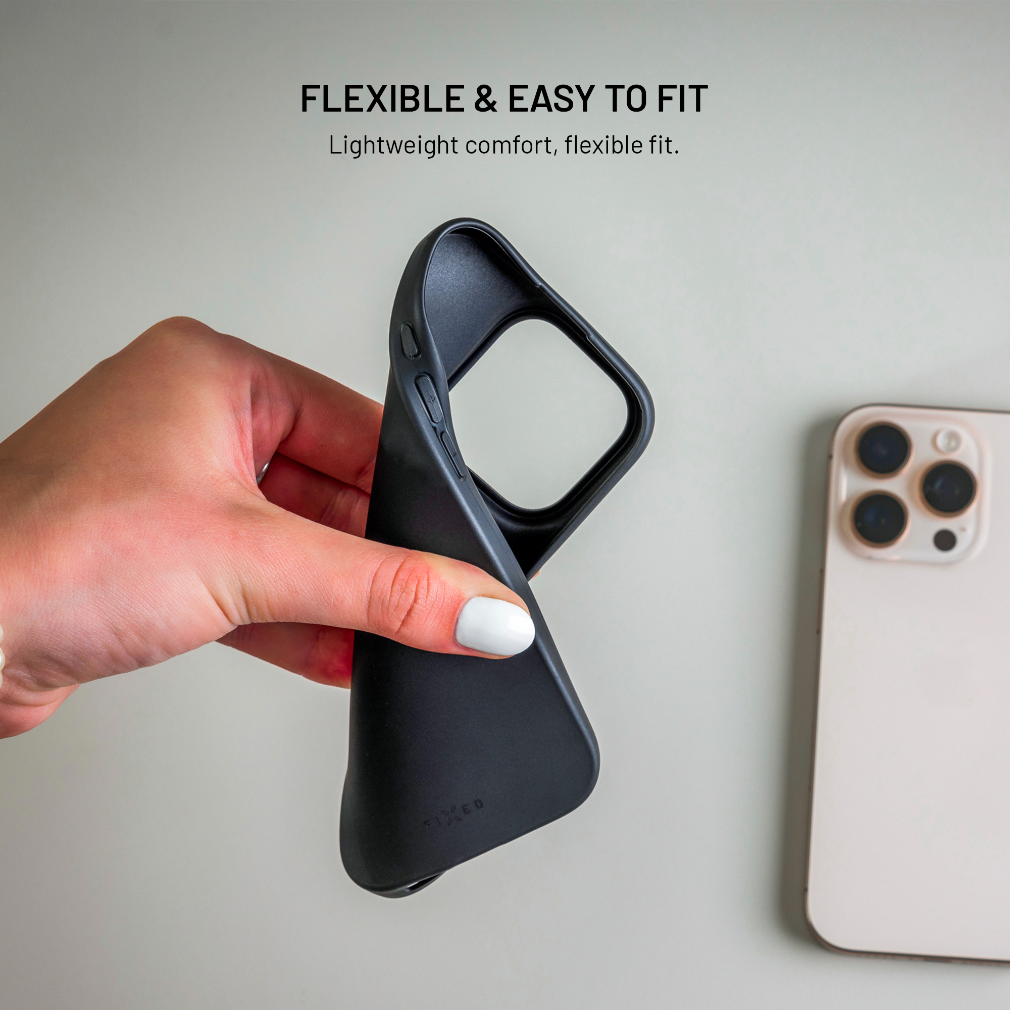 Eine Hand hält eine schwarze Handyhülle neben einem Smartphone.