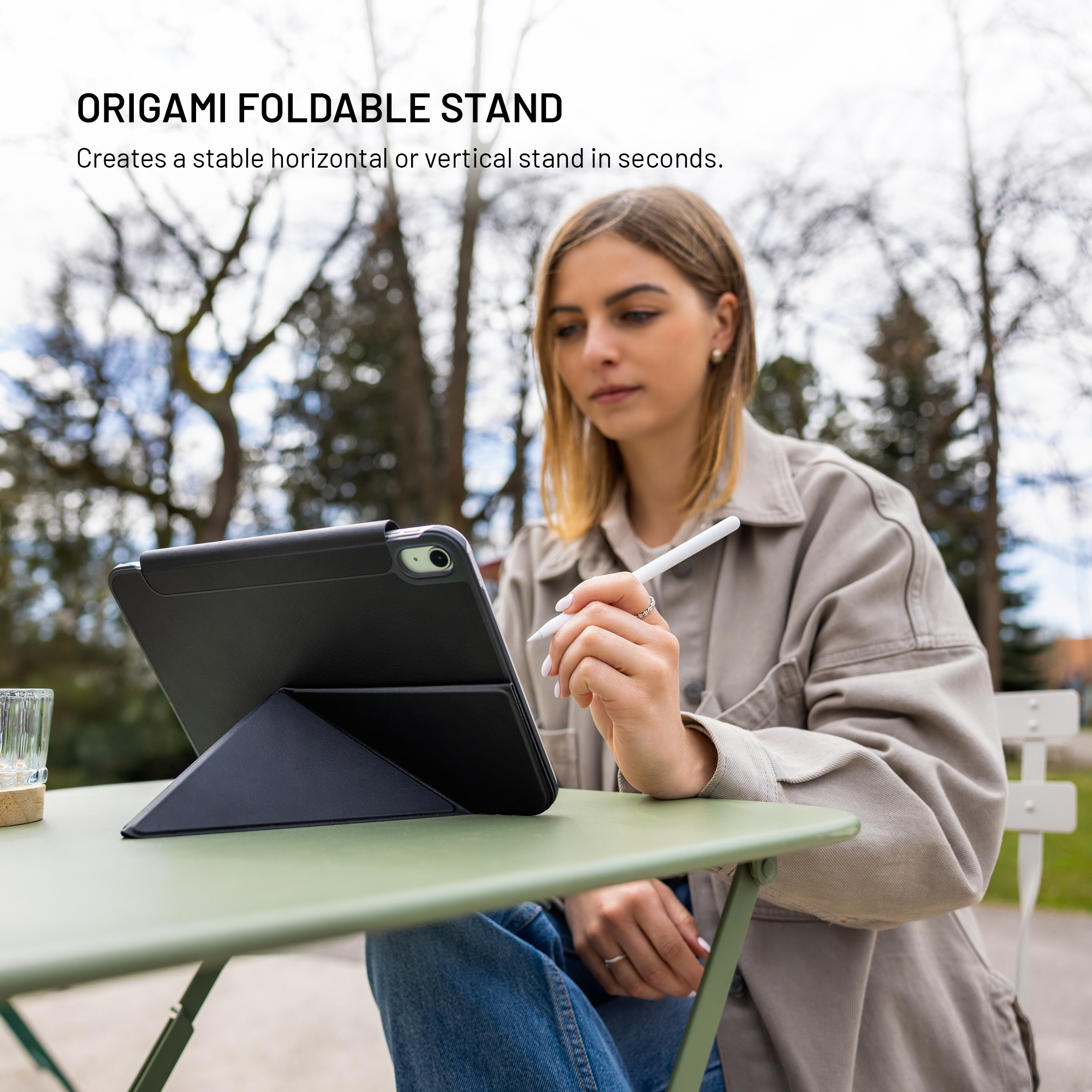 Eine Frau benutzt draußen einen Tablet-Ständer auf einem Tisch.