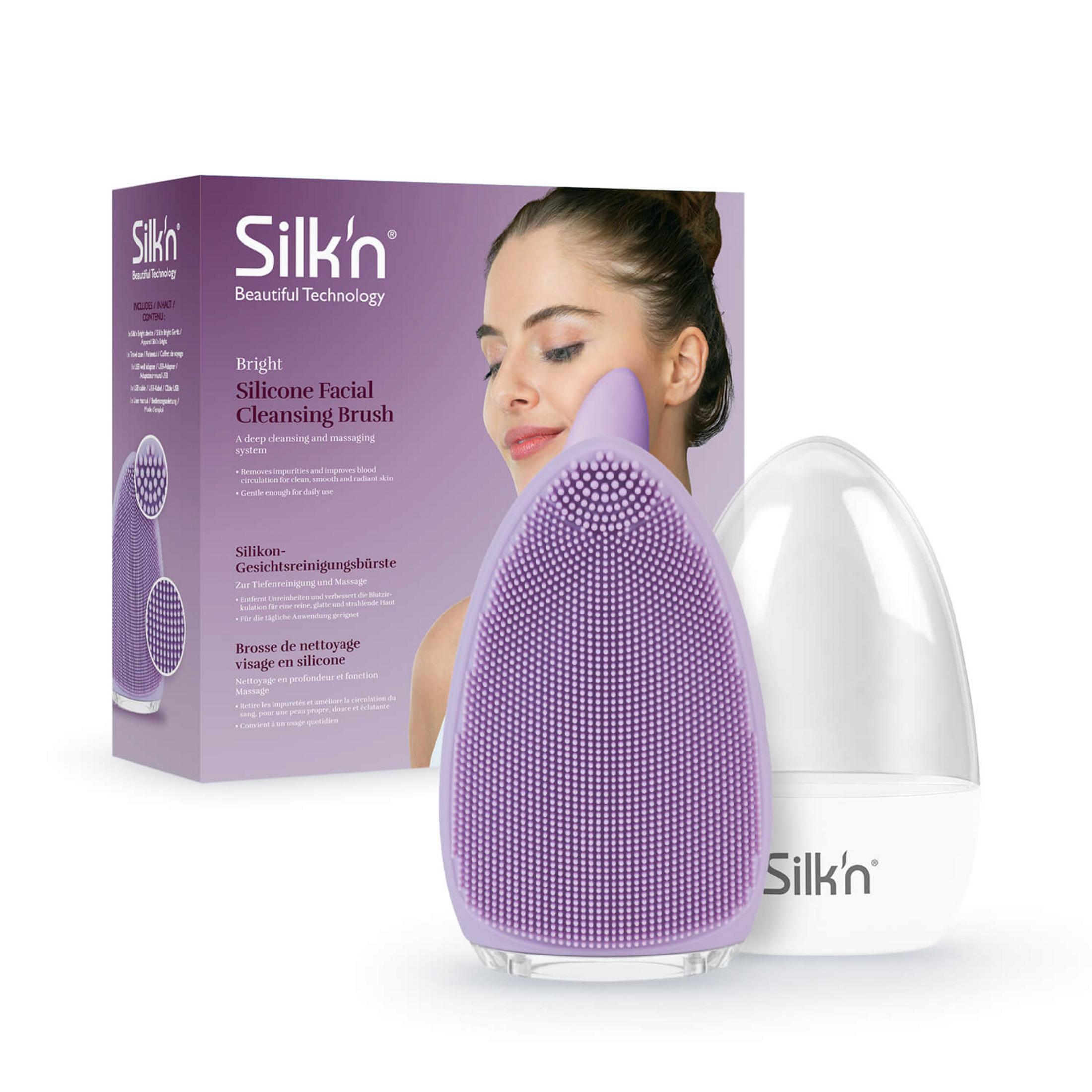 Lila Silikon-Gesichtsreinigungsbürste mit weißem Sockel und Verpackung.