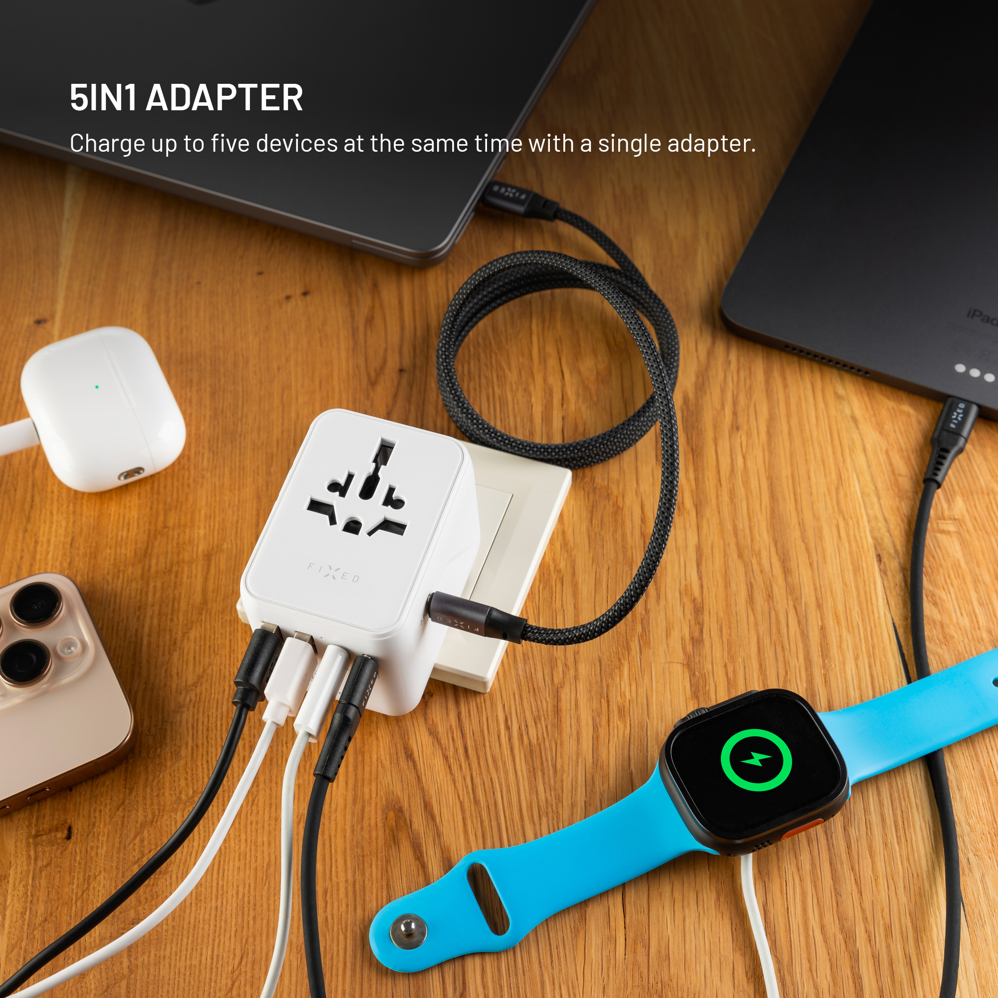 Ein weißer 5-in-1-Adapter lädt ein iPhone, AirPods, eine Apple Watch und ein iPad.