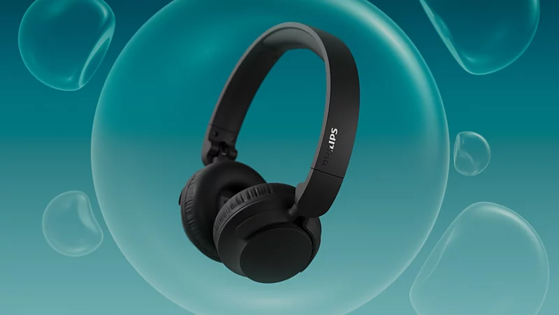 Schwarze Kopfhörer mit Philips-Logo, umgeben von blauen Blasen auf blauem Hintergrund.