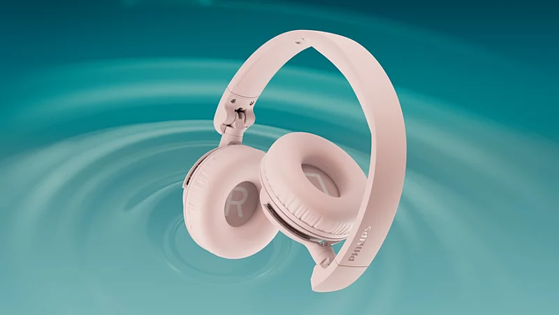 Ein rosa Philips Kopfhörer liegt auf einem blauen, welligen Hintergrund.