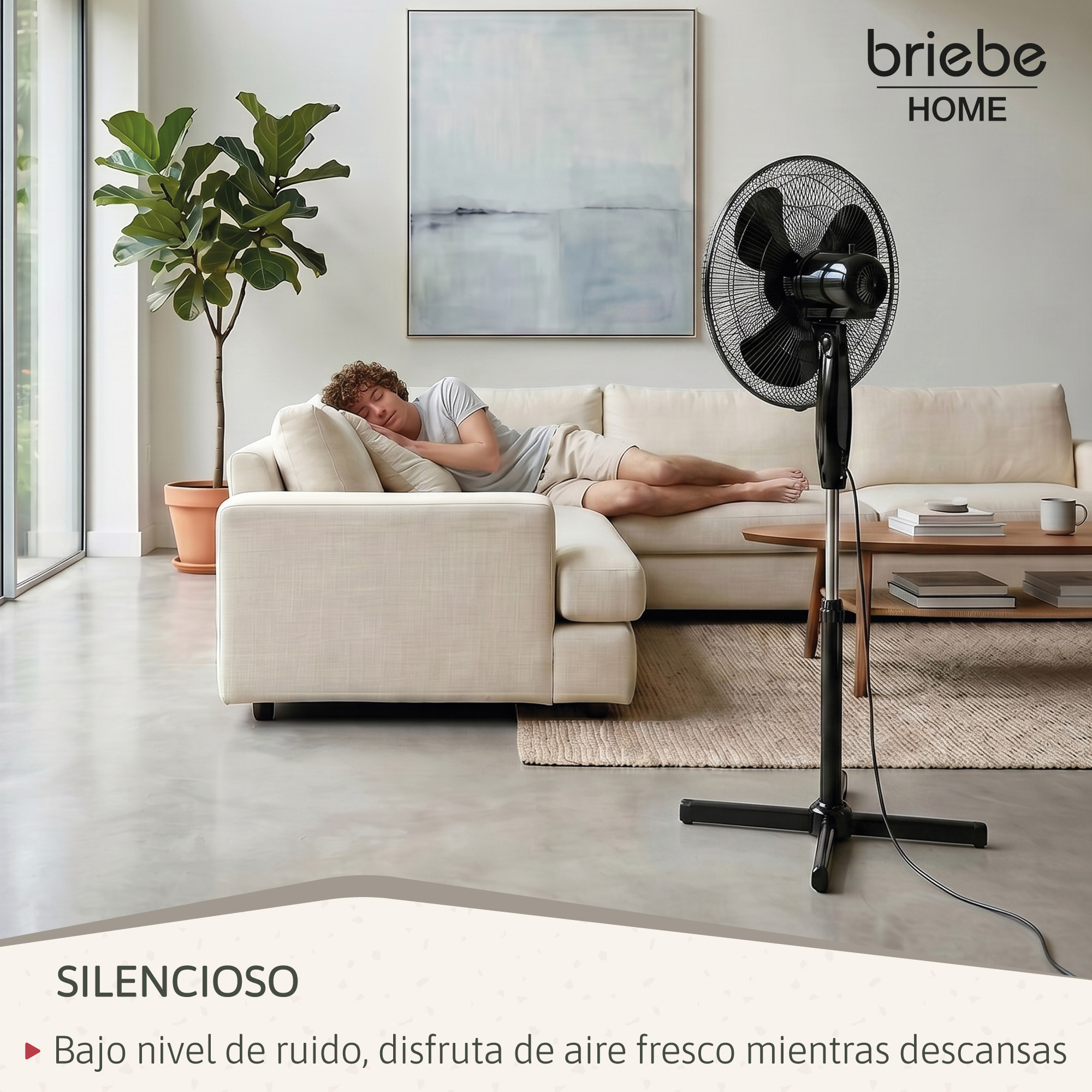 Un hombre duerme en un sofá con un ventilador cerca.