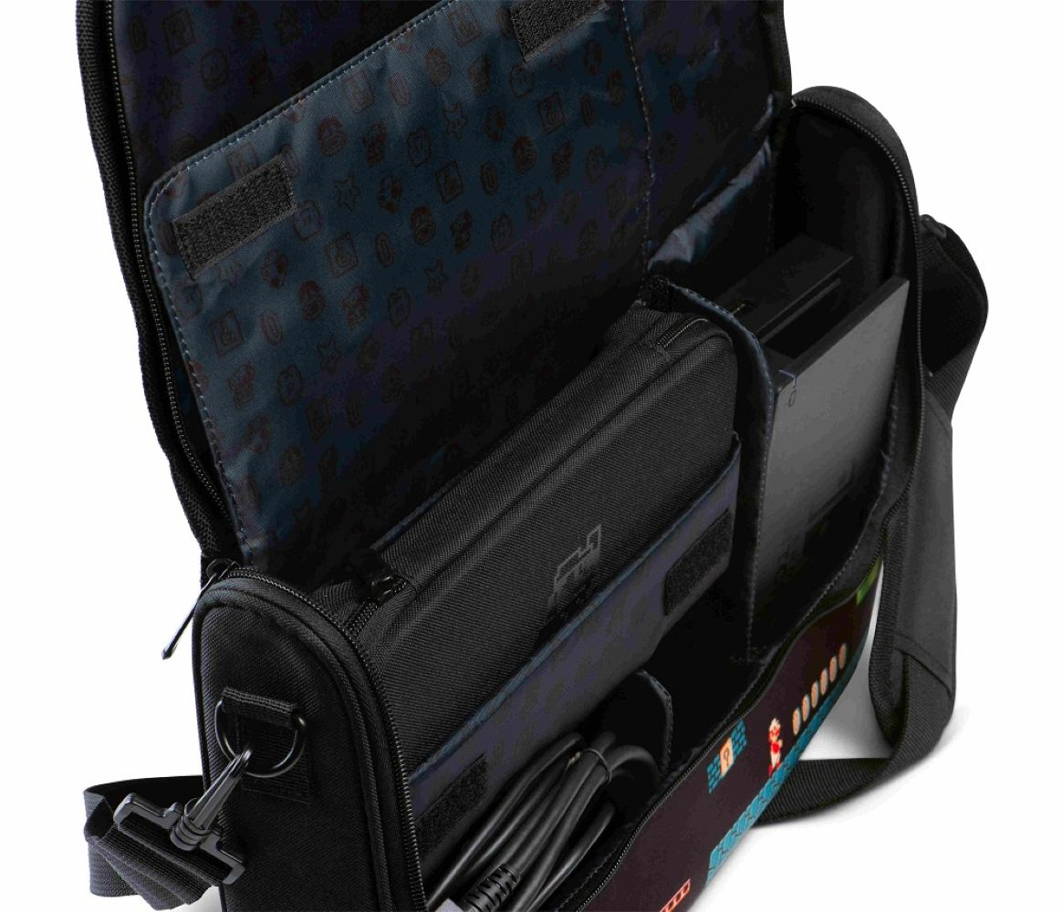 Borsa nera con motivo videoludico, aperta, mostra console, cavi e accessori all'interno.