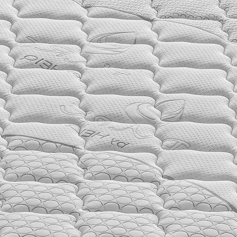 Colchón blanco acolchado con patrones y costuras en relieve.
