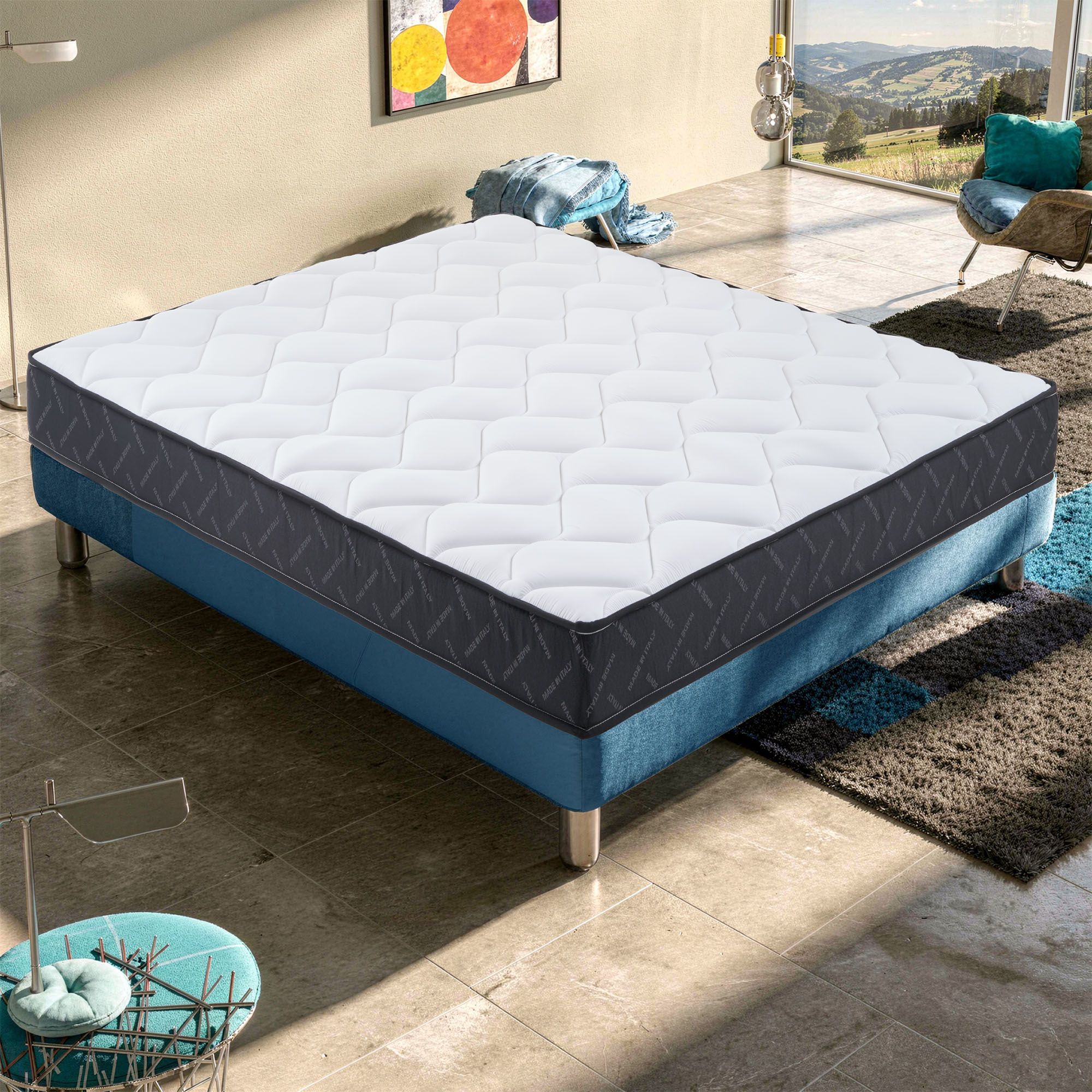 Un set de colchón blanco sobre una base de cama azul en una habitación luminosa.