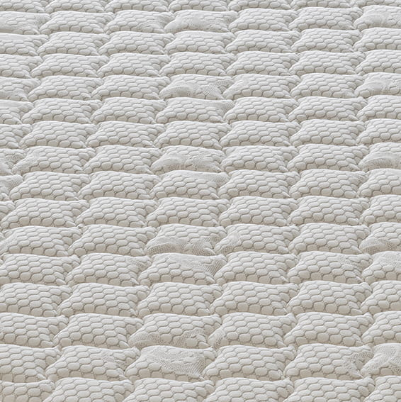 Primer plano abstracto de una superficie acolchada beige claro con patrón de panal.