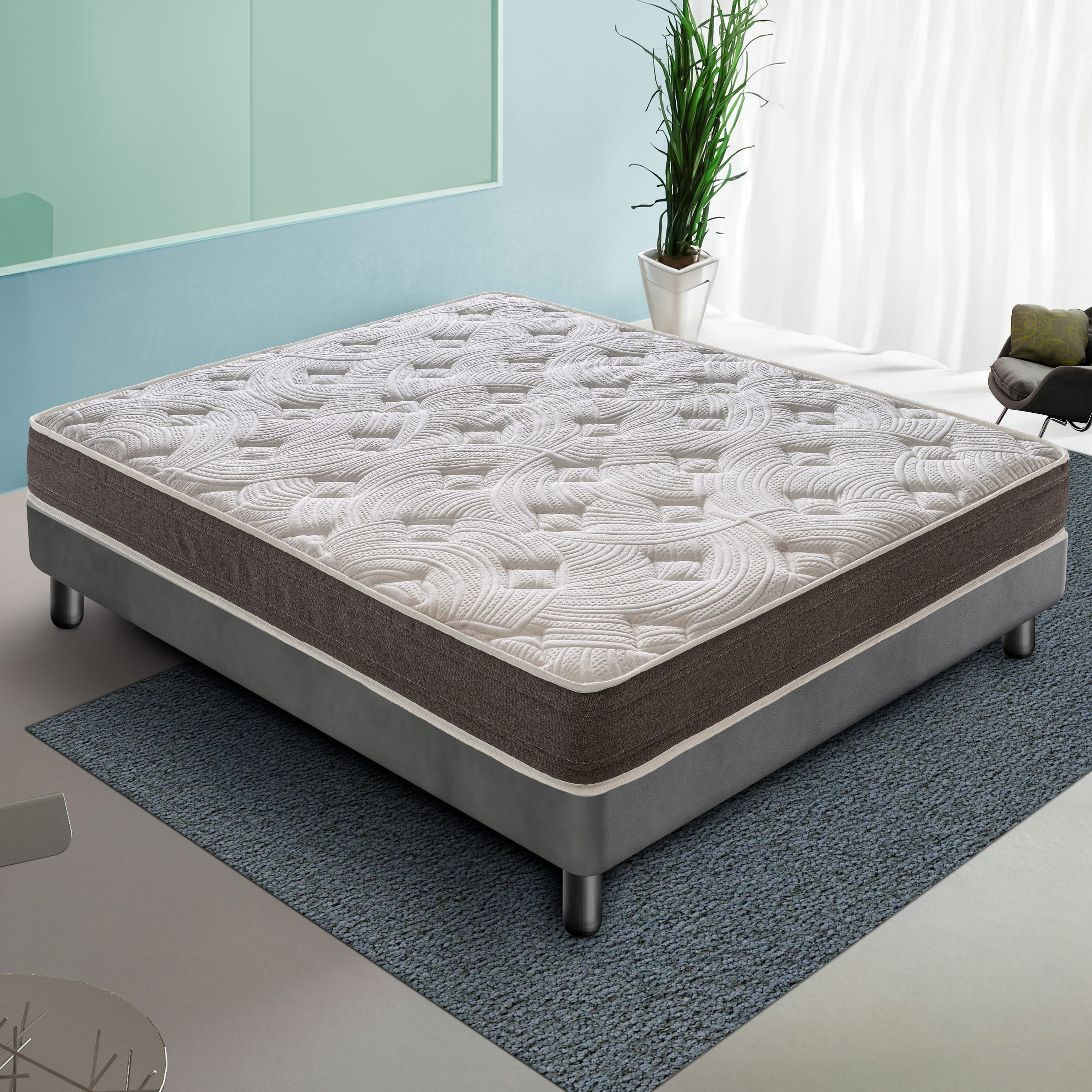Una cama con un colchón blanco estampado y un somier gris, en una habitación.