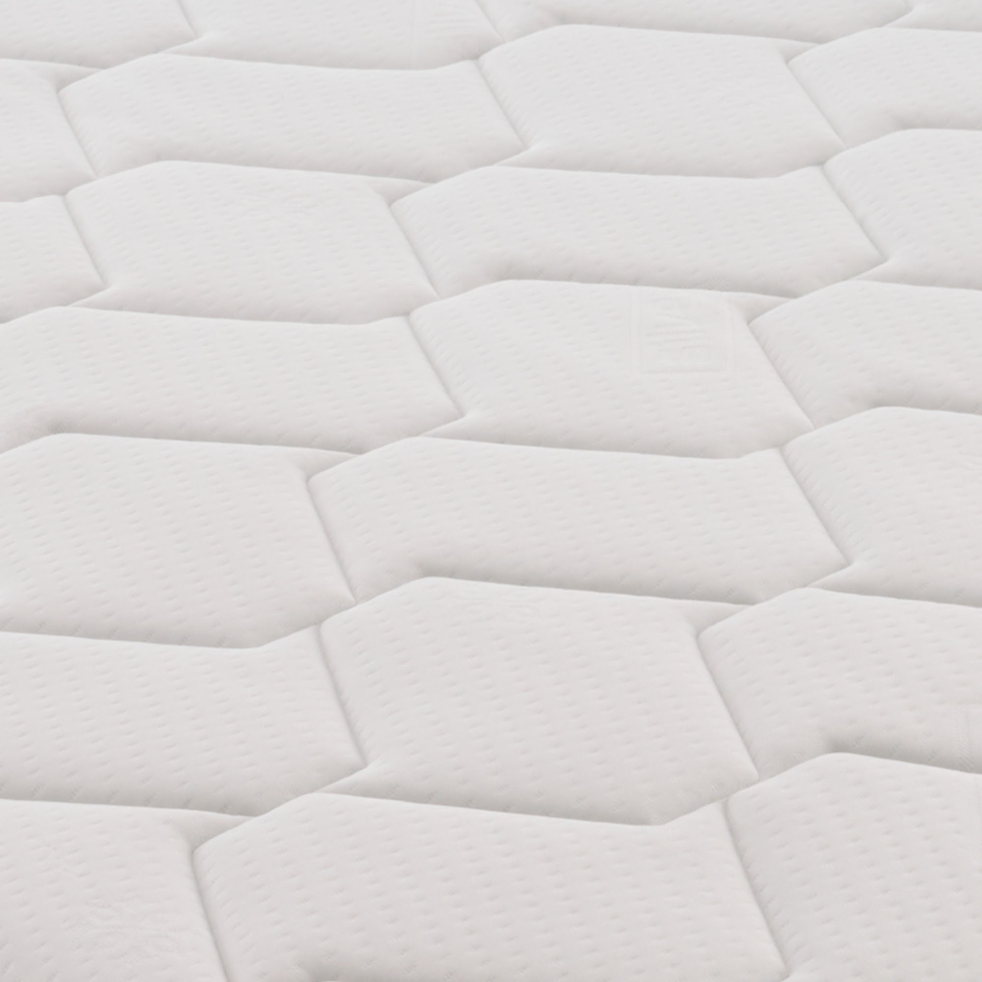 Primer plano abstracto de un colchón blanco acolchado con patrones hexagonales.