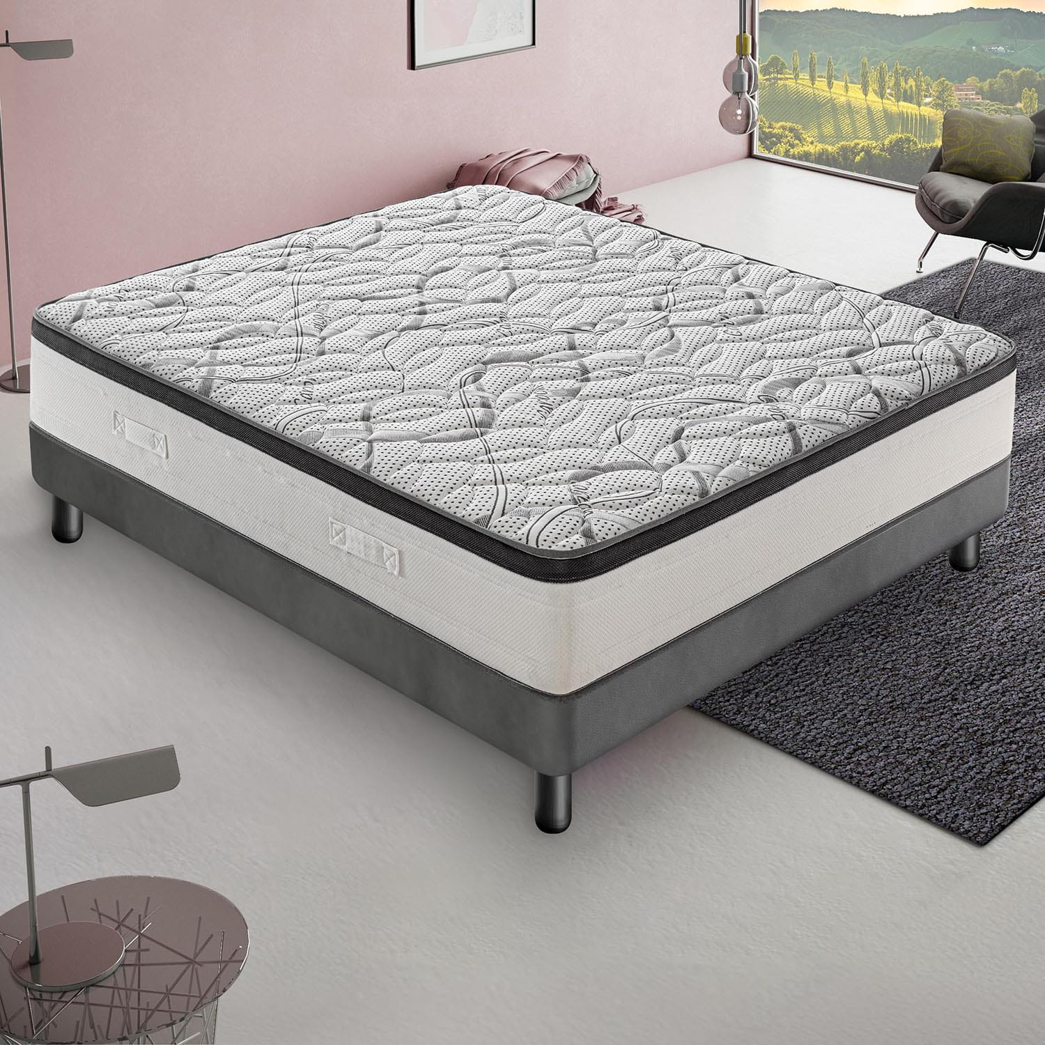 Un colchón blanco y gris estampado sobre base gris, en habitación con paredes rosas y ventana grande.