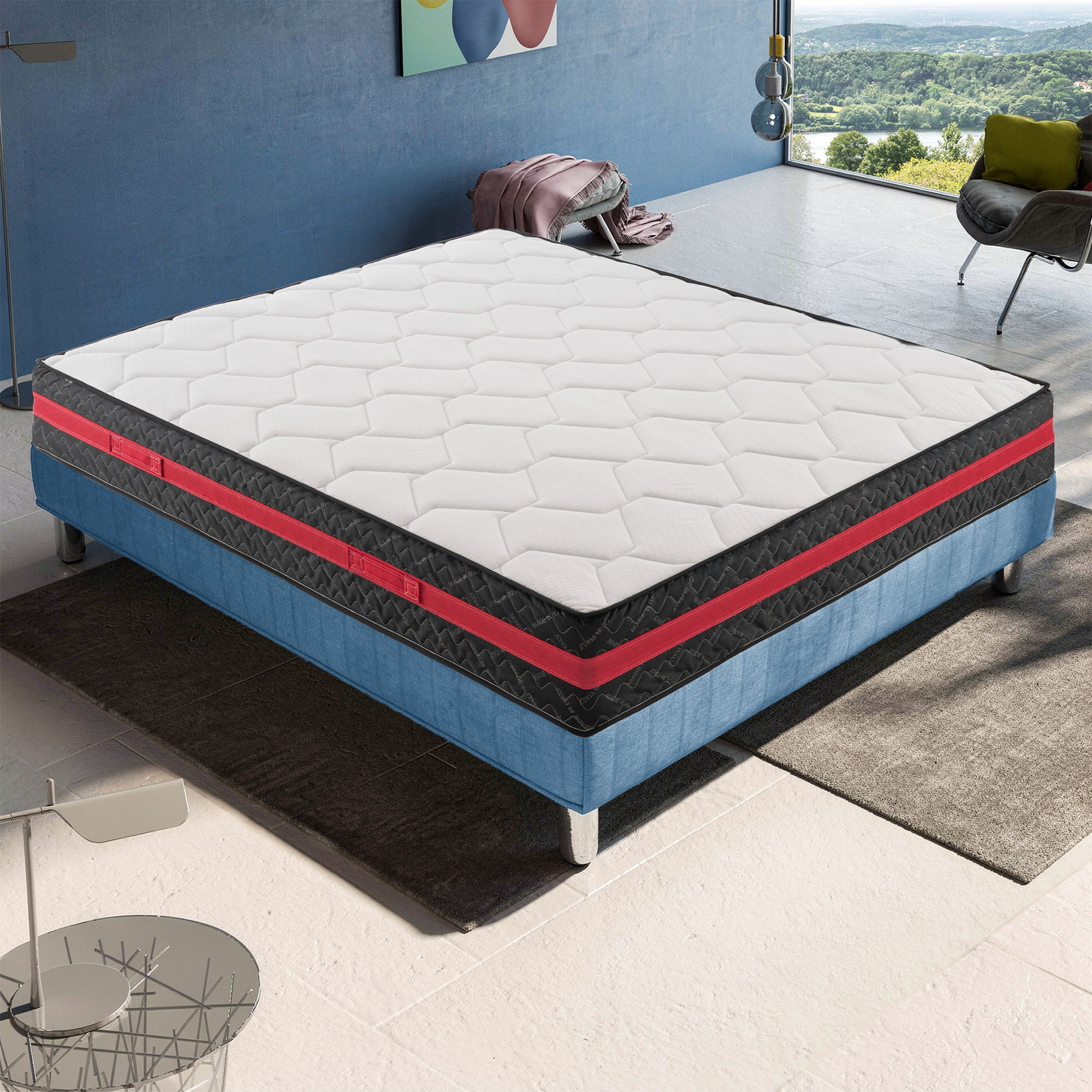 Un juego de colchón blanco con base azul y detalles rojos está sobre una alfombra.