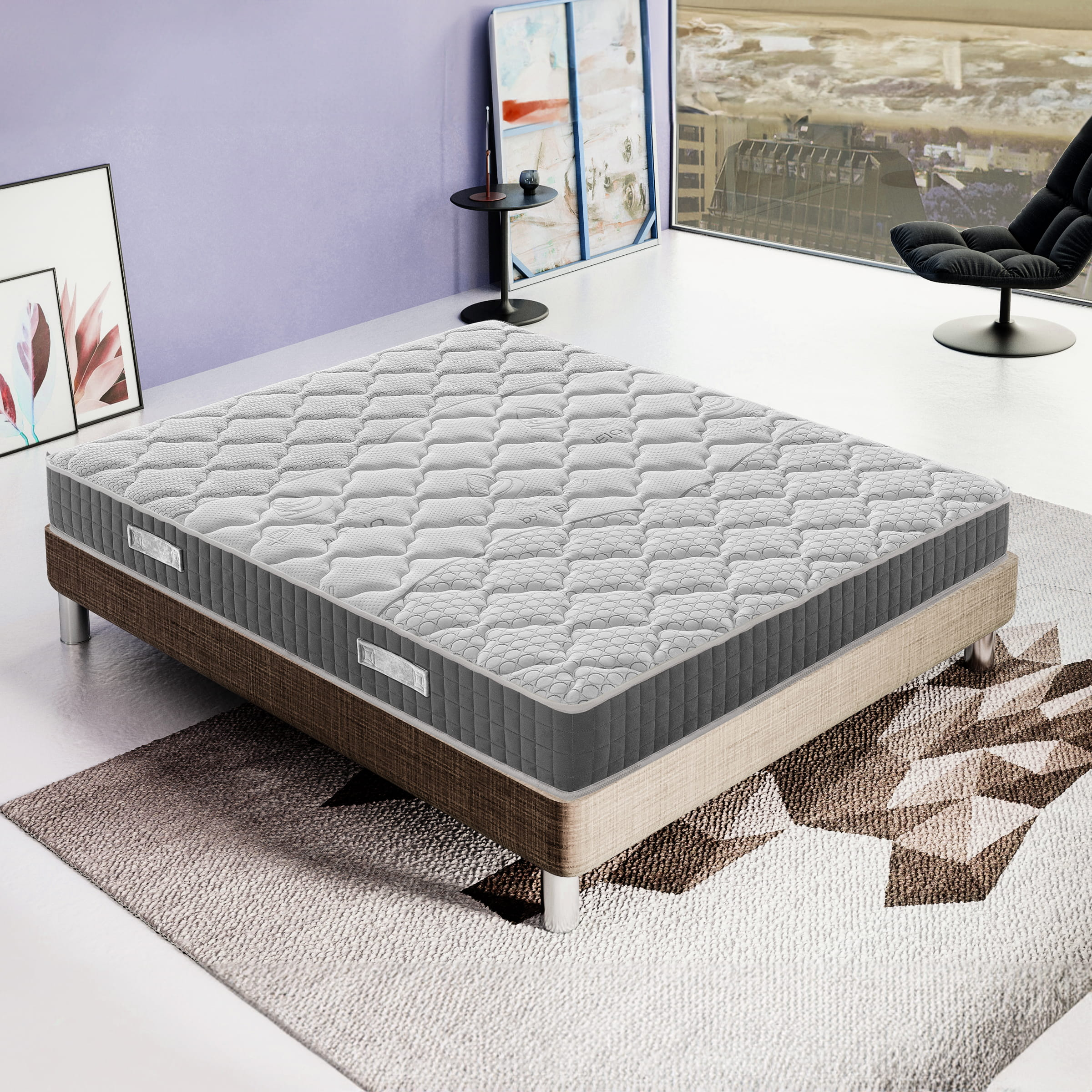 Una cama gris con un colchón estampado está sobre una alfombra.