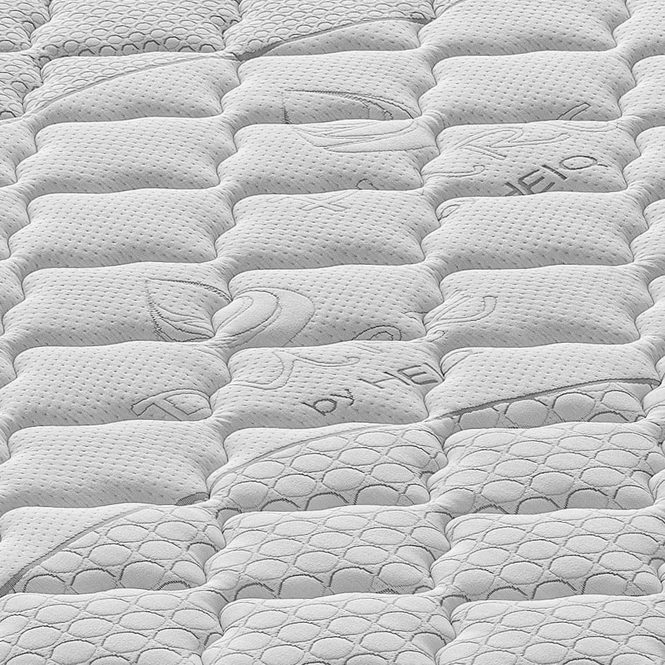 Colchón blanco acolchado con varios patrones y costuras.