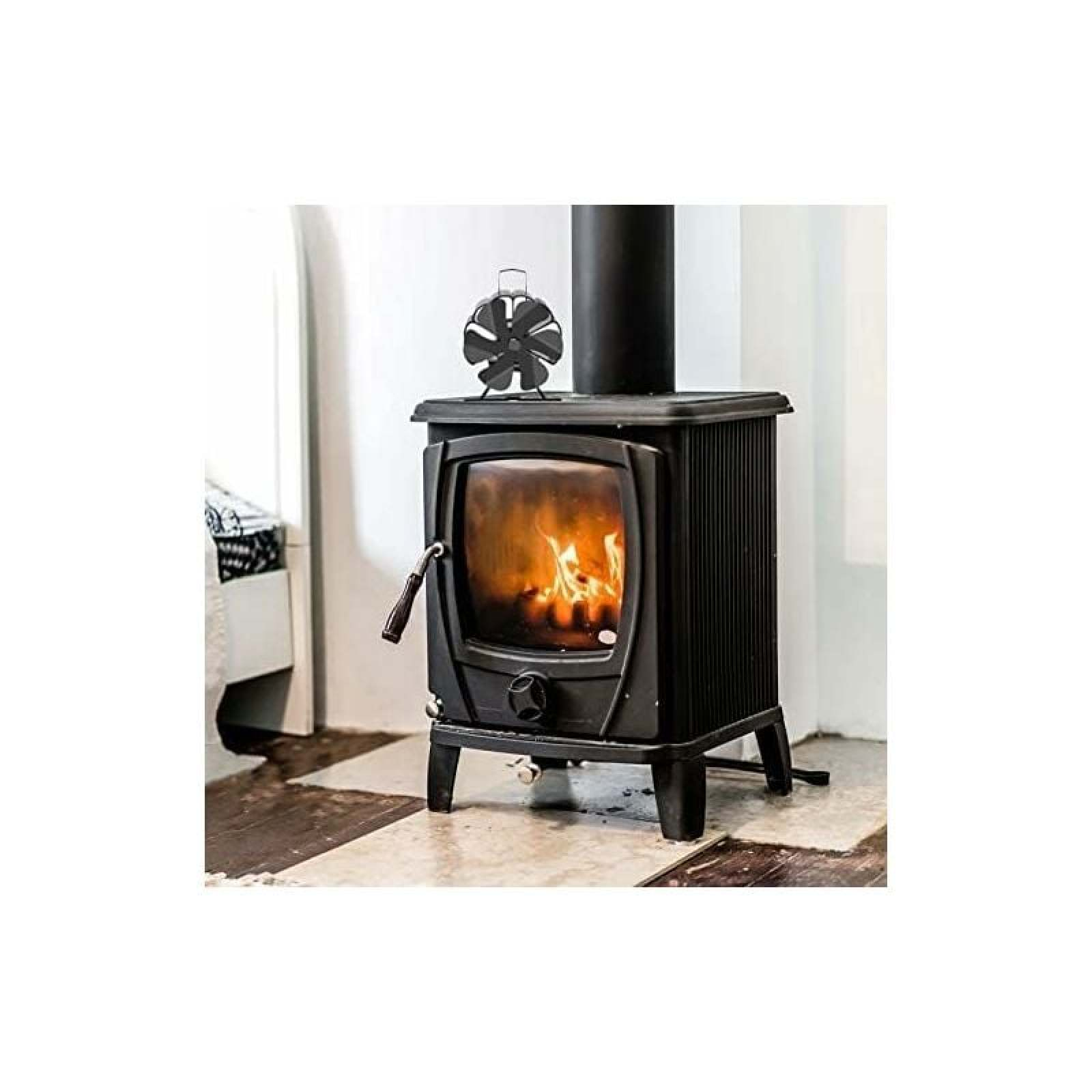 Schwarzer Holzofen mit brennendem Feuer und einem Lüfter auf dem Schornstein.