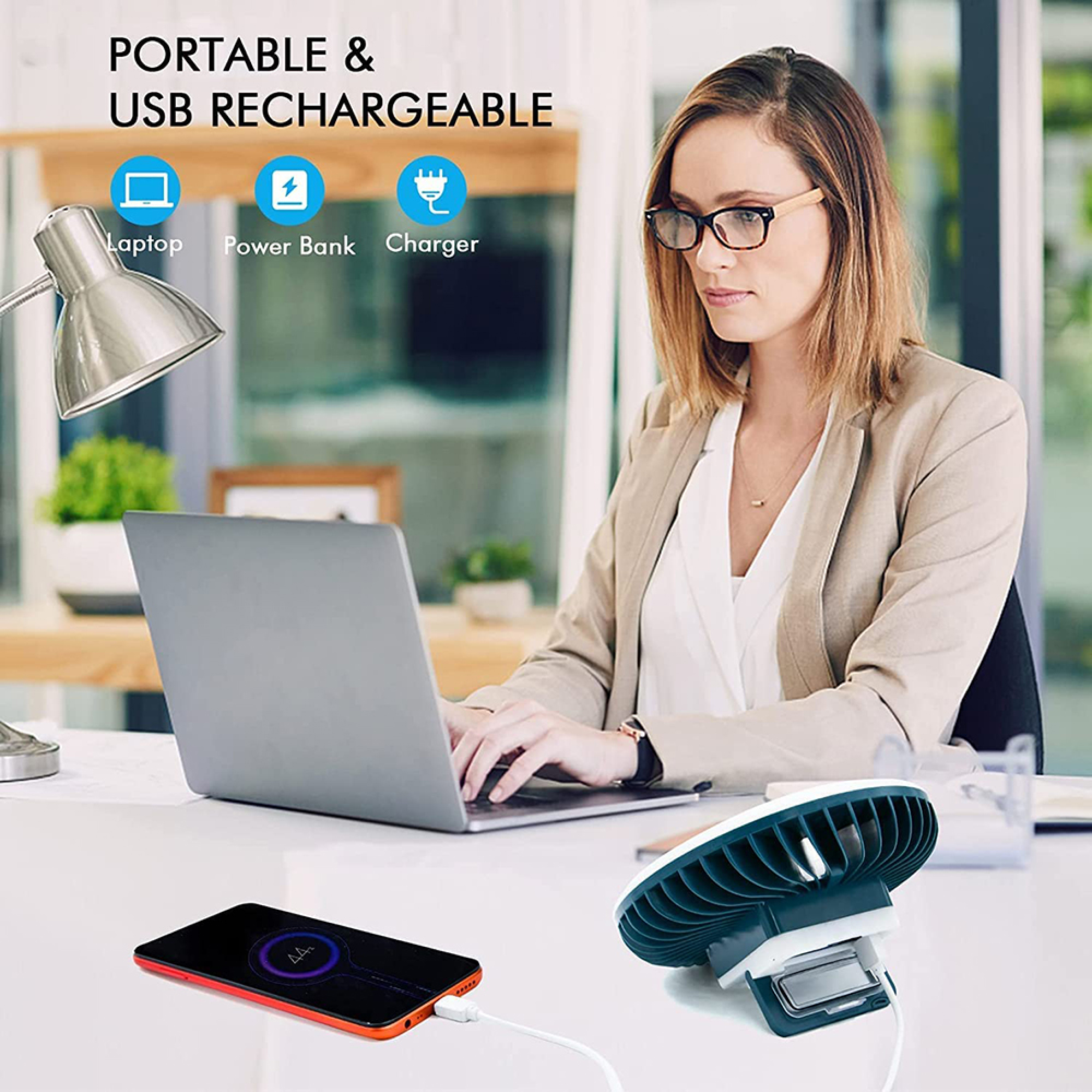 Frau am Schreibtisch mit Laptop, Handy und Lüfter.