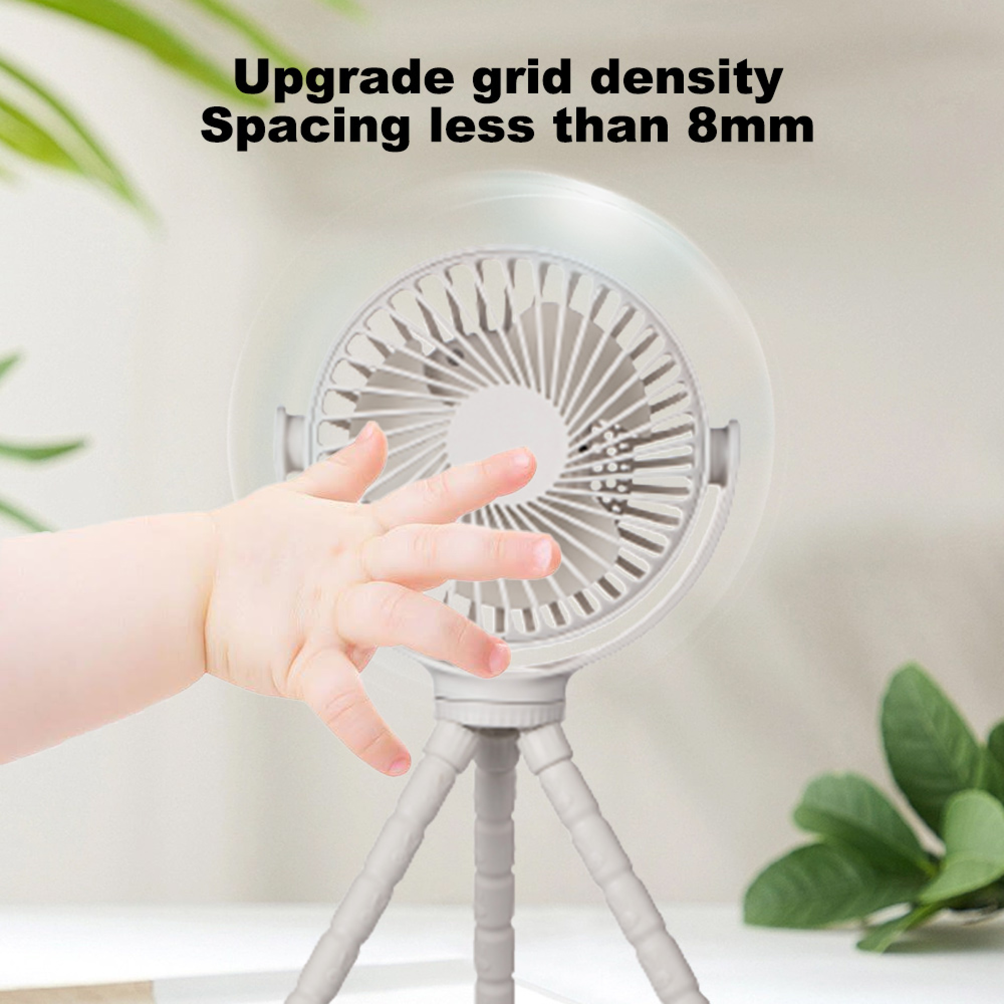 Ein Babyfinger nähert sich einem kleinen weißen Ventilator auf einem grauen Stativ.