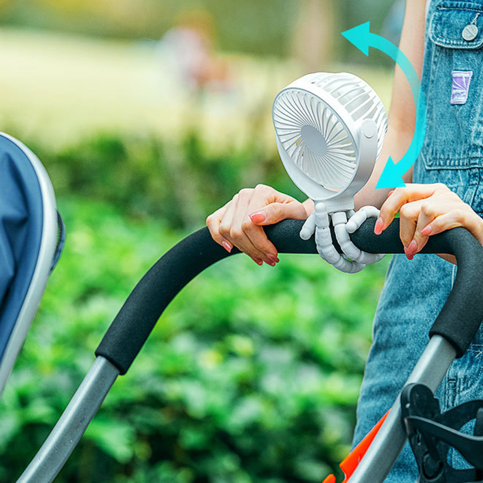 Ein weißer Kinderwagenventilator mit flexiblen Armen, der an einem Kinderwagengriff befestigt ist.