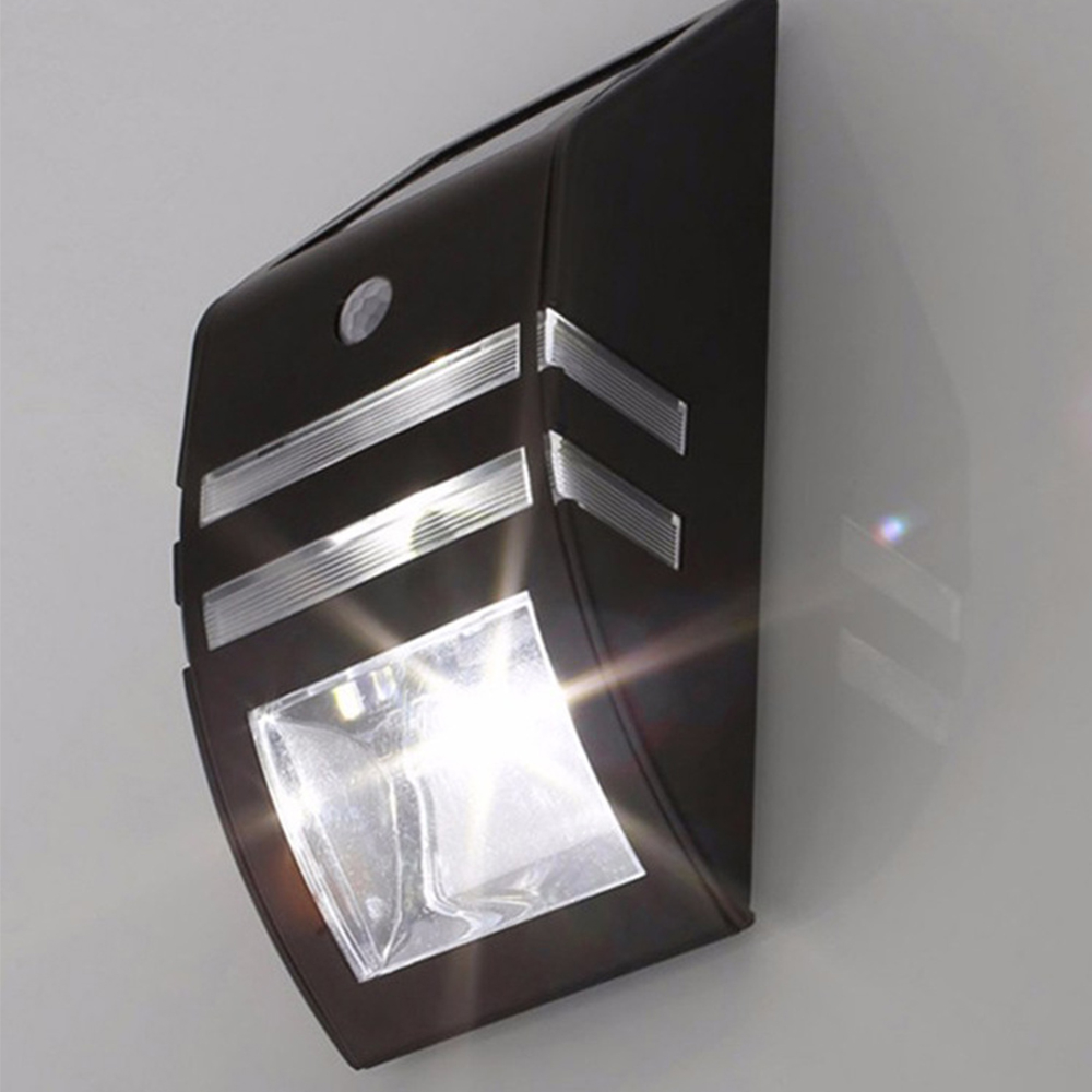 Eine dunkelbraune solarbetriebene Wandleuchte mit Bewegungsmelder und hellem LED-Licht.