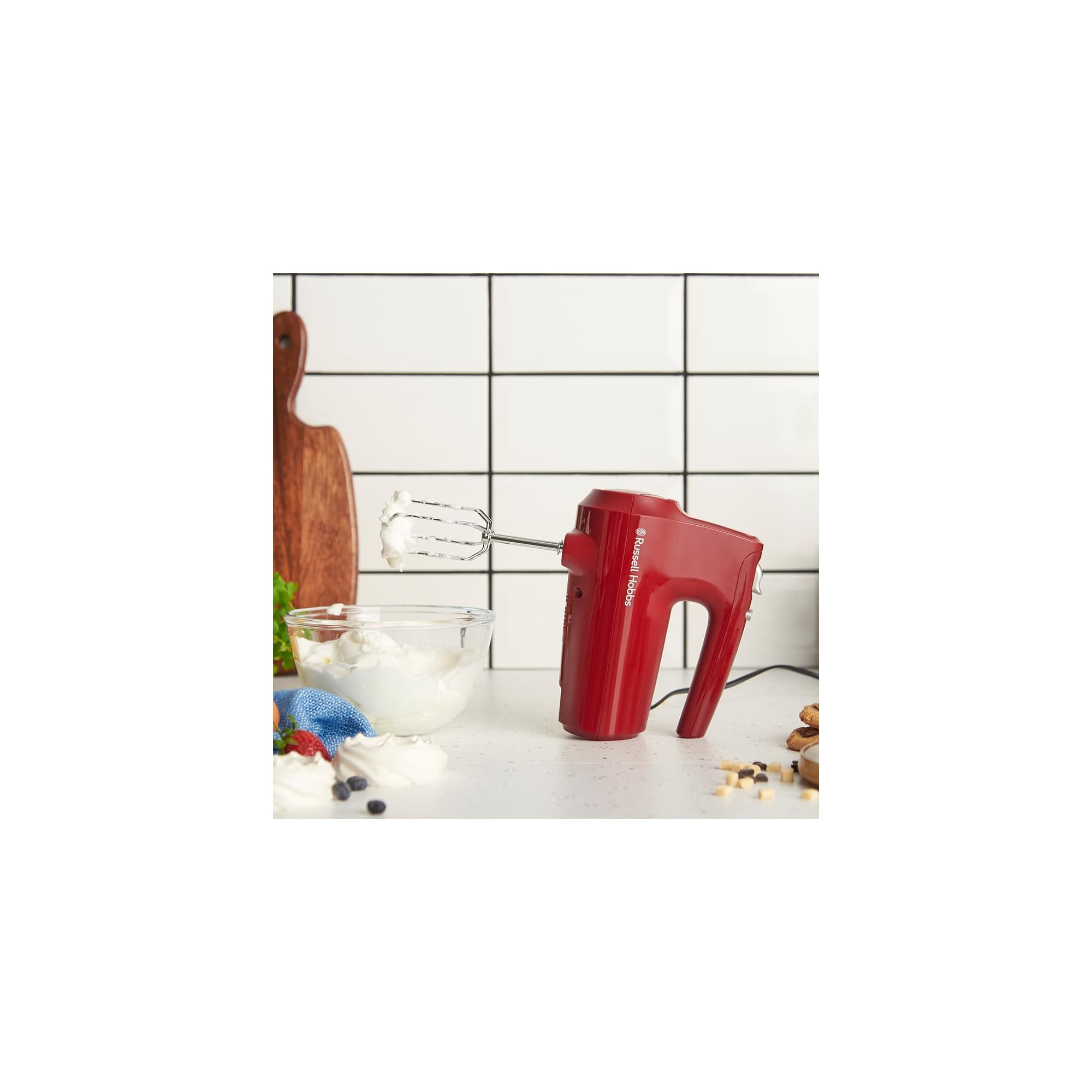 Ein roter Handmixer mit Schneebesen ist neben einer Schüssel Schlagsahne abgebildet.