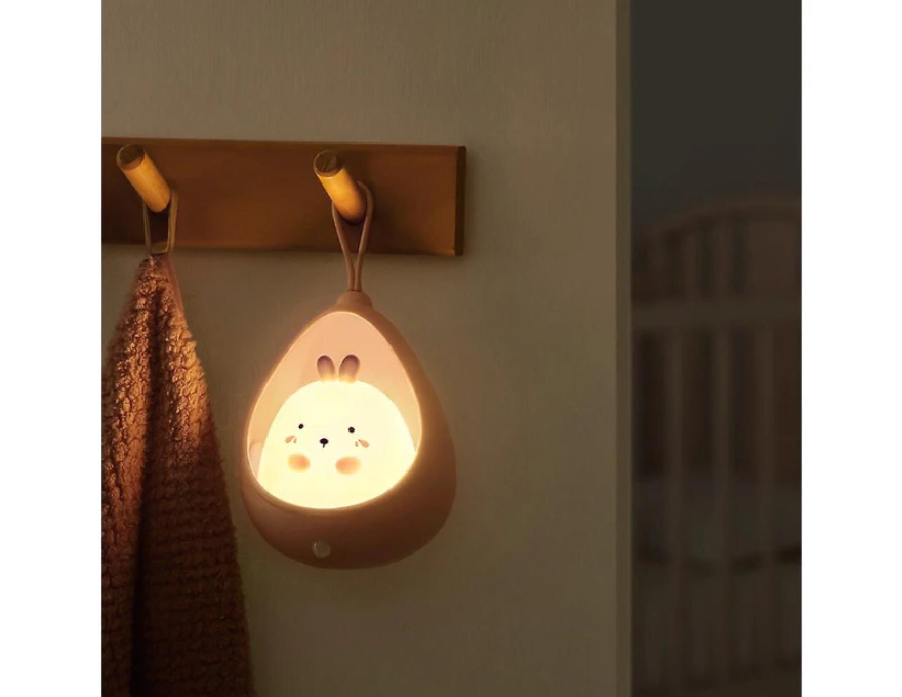 Eine niedliche Nachtlampe in Hasenform, die an einem Haken hängt.
