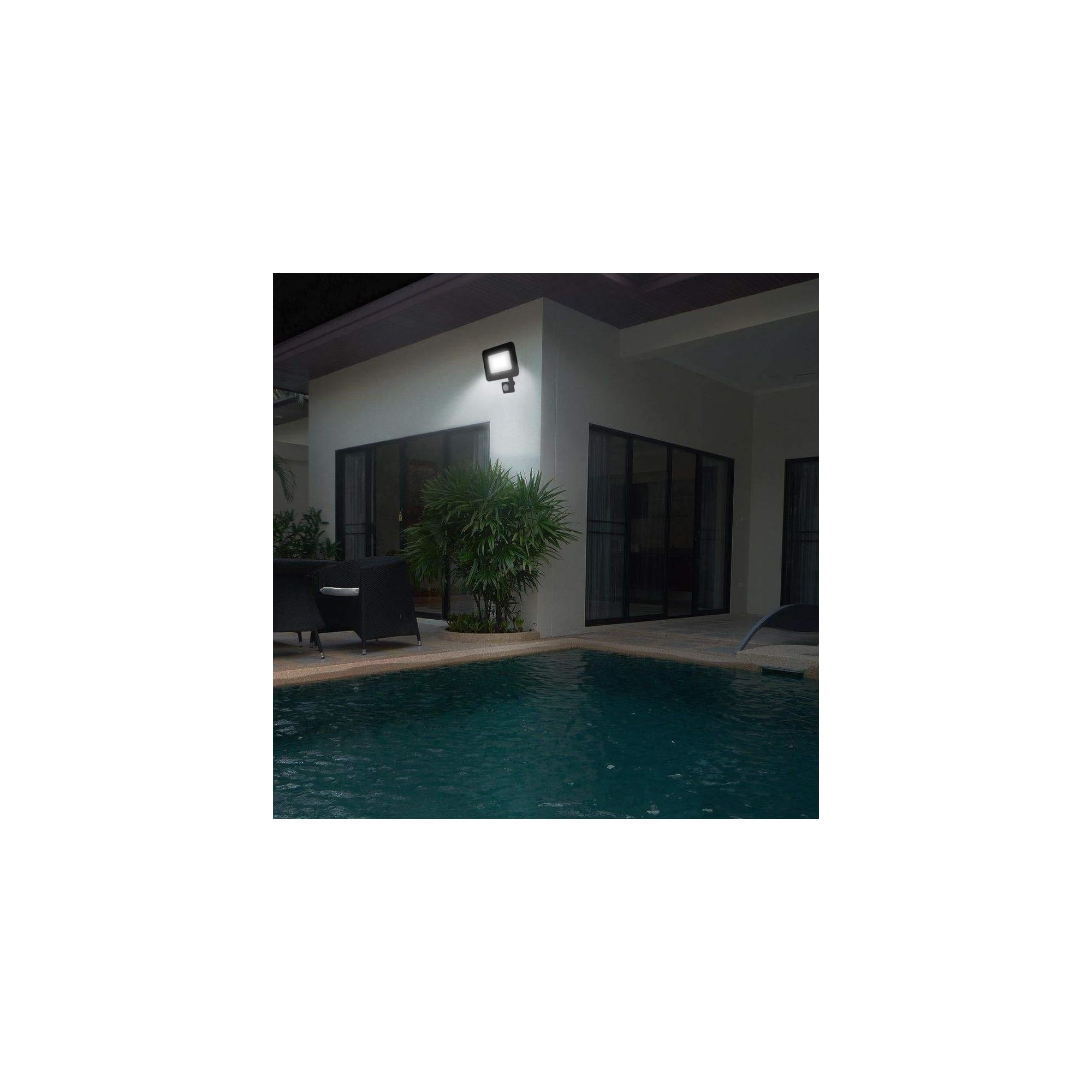 Ein dunkler moderner Scheinwerfer beleuchtet eine weiße Wand über einem Pool.