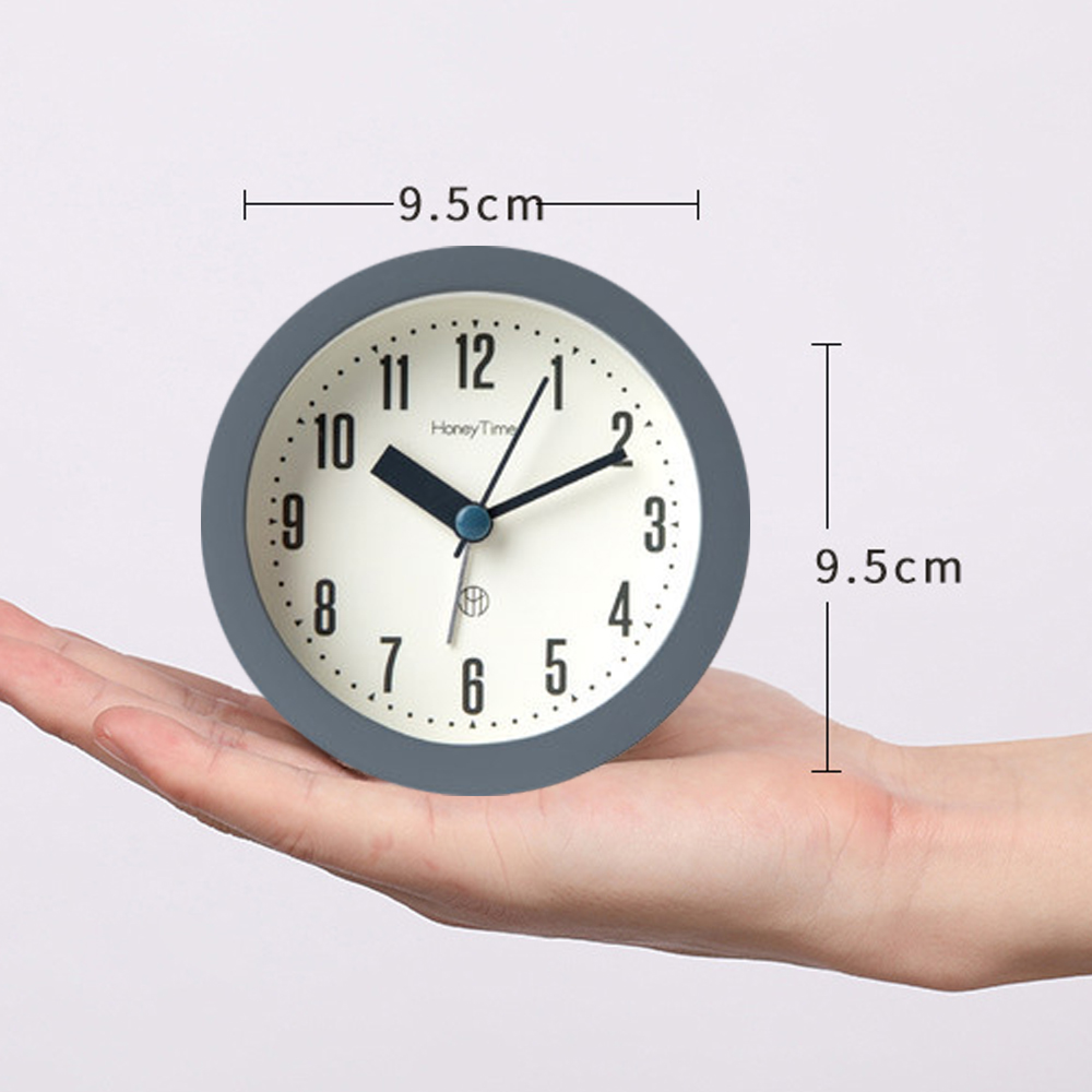 Graue Uhr auf einer Hand, Maße 9,5 cm in beide Richtungen.