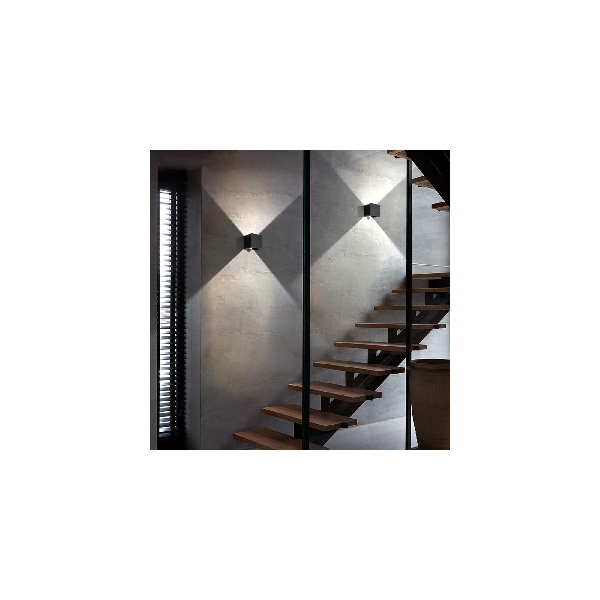 Moderne Holztreppe mit Metallgeländer und zwei Wandleuchten an Betonwand.