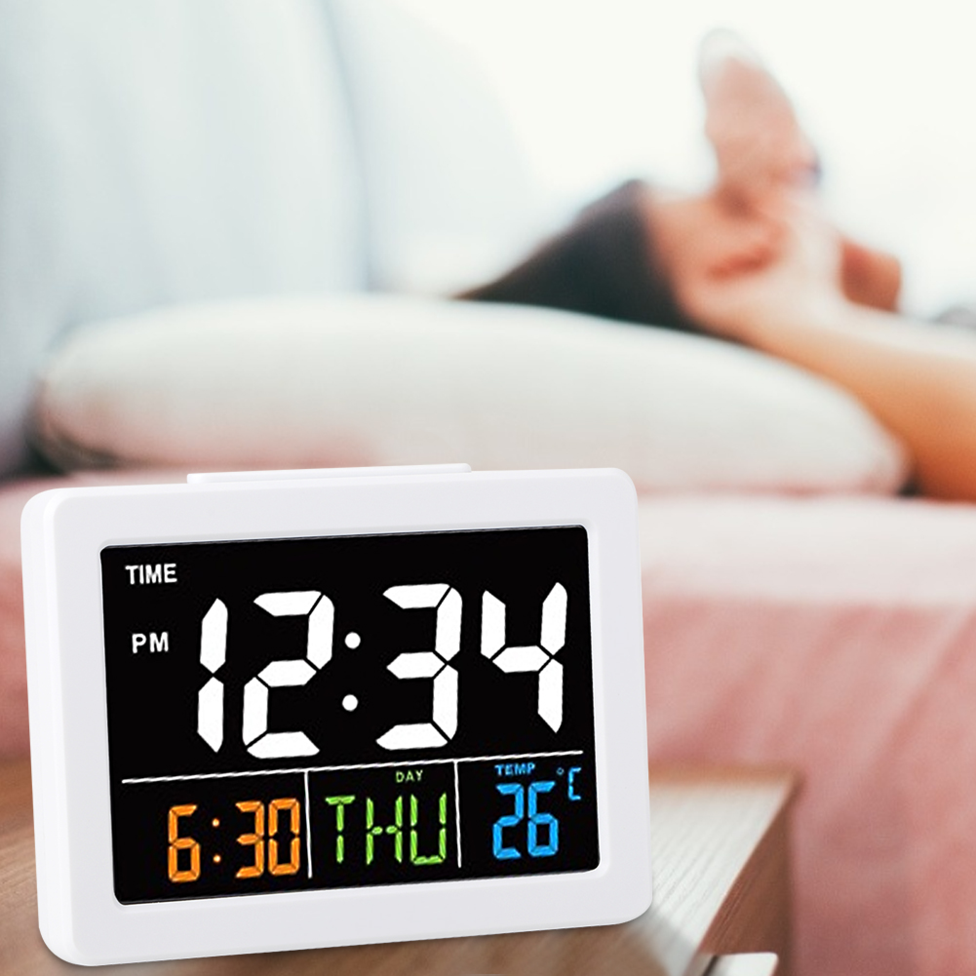 Ein digitaler Wecker zeigt 12:34 Uhr, 6:30 Uhr, Donnerstag und 26°C an.