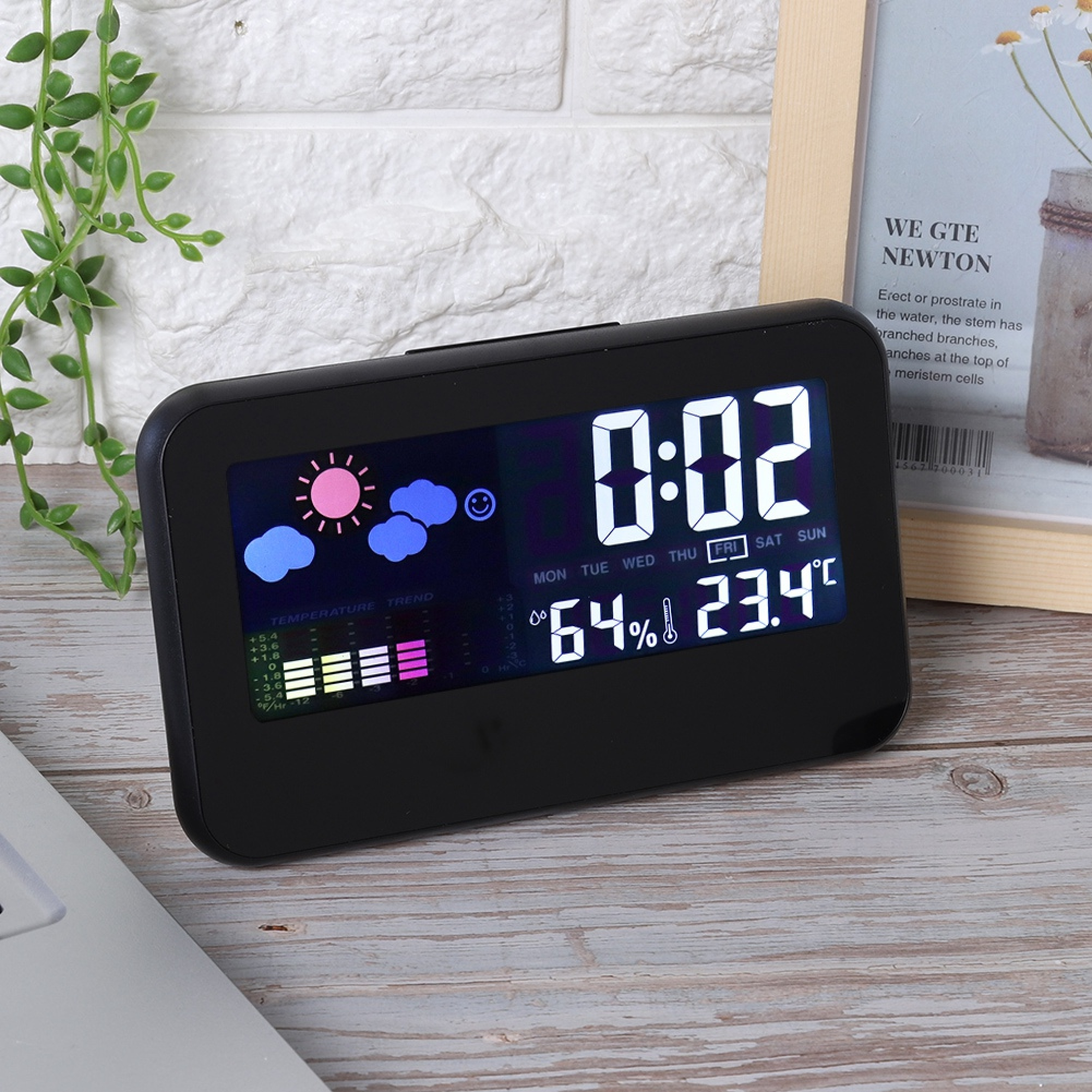 Ein schwarzes Digitaluhr zeigt 0:02 Uhr, 64% Luftfeuchtigkeit, 23.4°C.