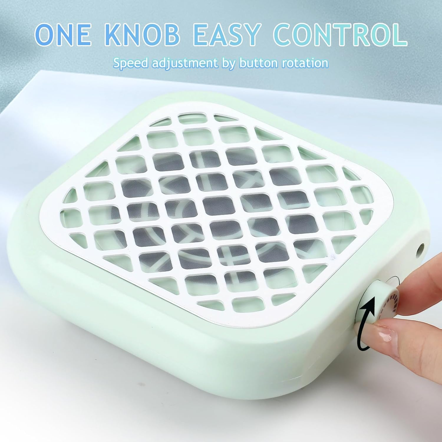 Ein hellgrüner Ventilator mit weißem Gitter ist zu sehen, eine Hand dreht den Geschwindigkeitsregler.