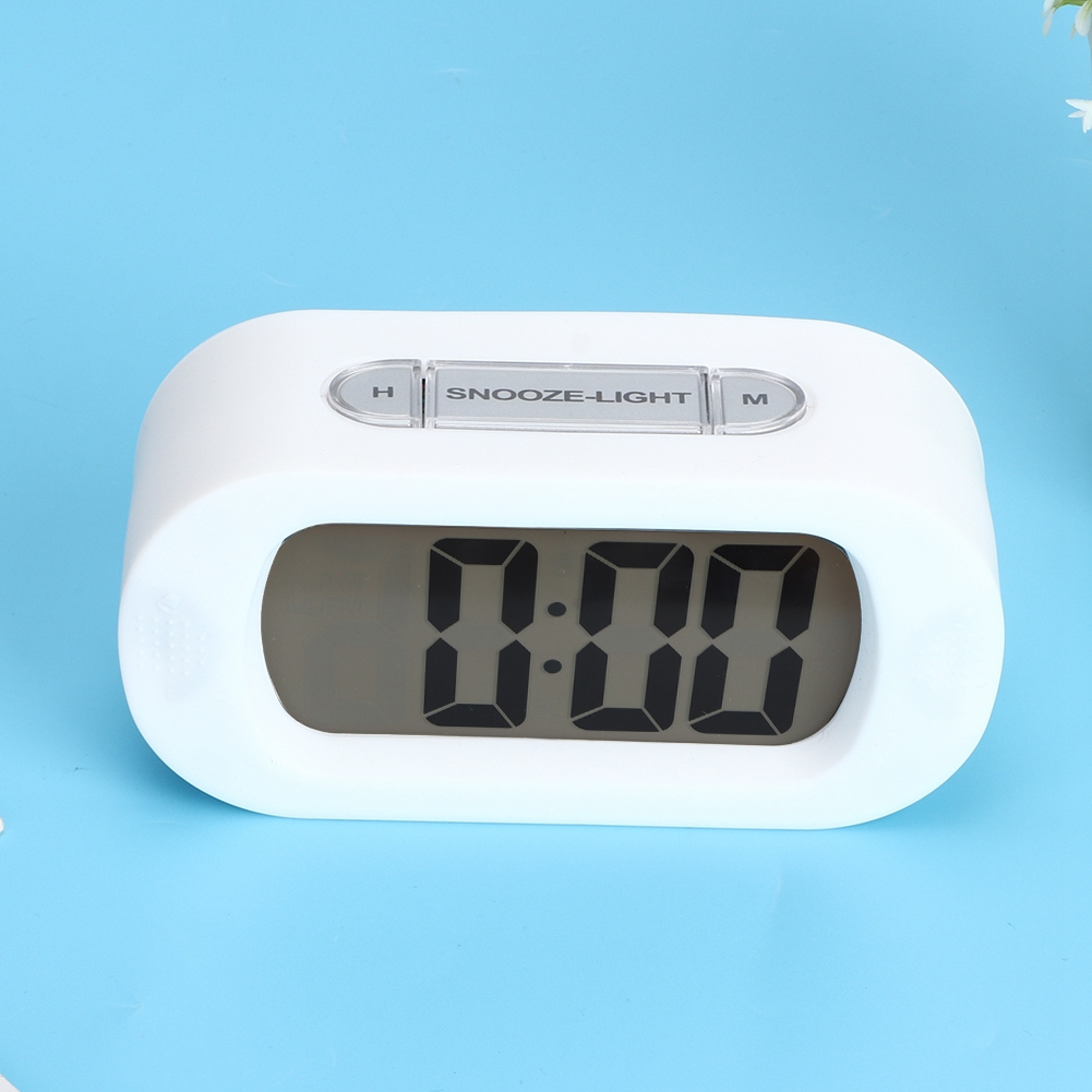 Ein weißer digitaler Wecker auf blauem Hintergrund zeigt 0:00 an.