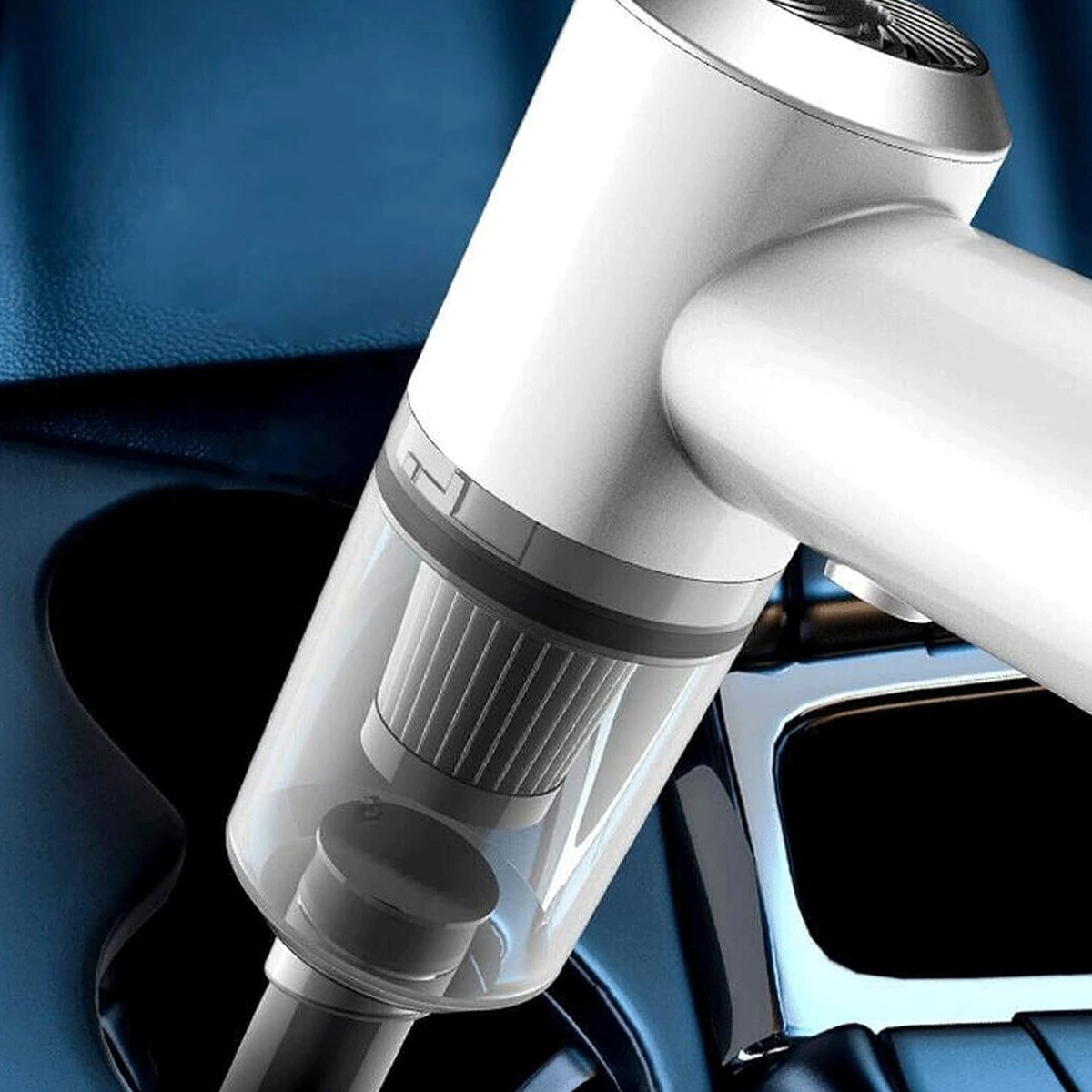 Ein weißer Handstaubsauger mit transparentem Behälter in einem Auto.