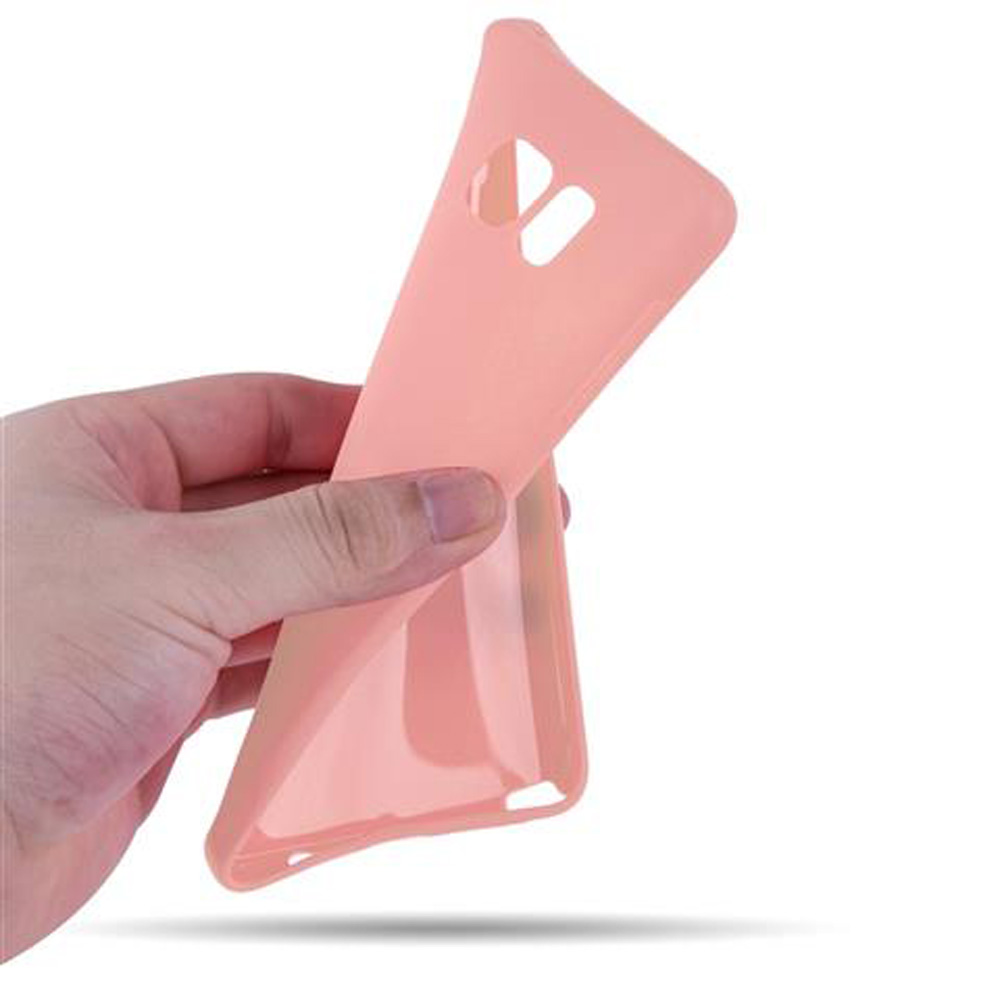Eine Hand hält eine pfirsichfarbene Handyhülle mit Ausschnitten für Kamera und Blitz.