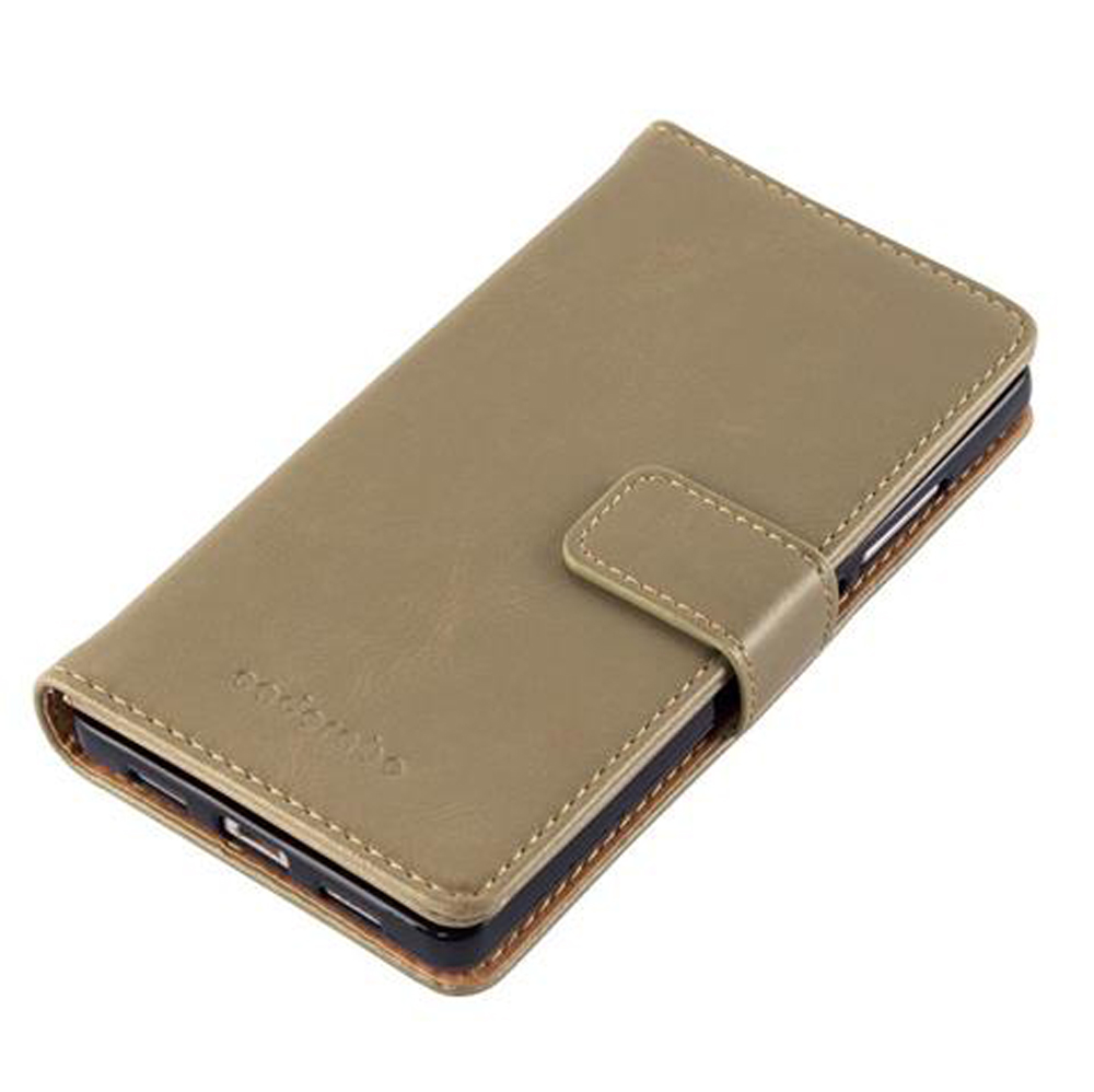 Una custodia a libro in pelle beige è adagiata su una superficie bianca.