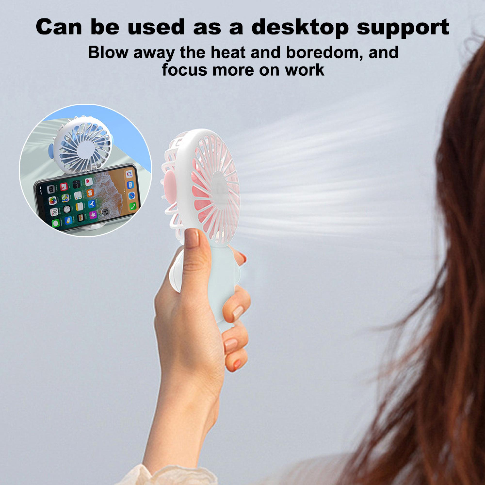 Eine Hand hält einen weißen tragbaren Ventilator, der Luft bläst. Ein Telefon mit Apps ist zu sehen.