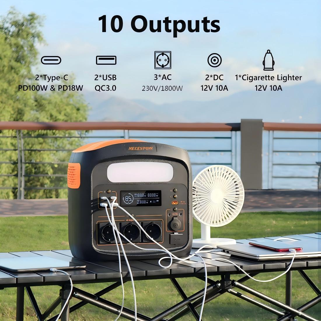Estación de energía portátil con 10 salidas, cargando dispositivos en una mesa al aire libre.