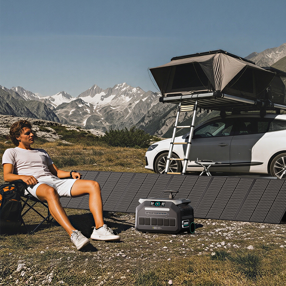 Hombre sentado en silla de camping ante coche con tienda de techo y paneles solares.