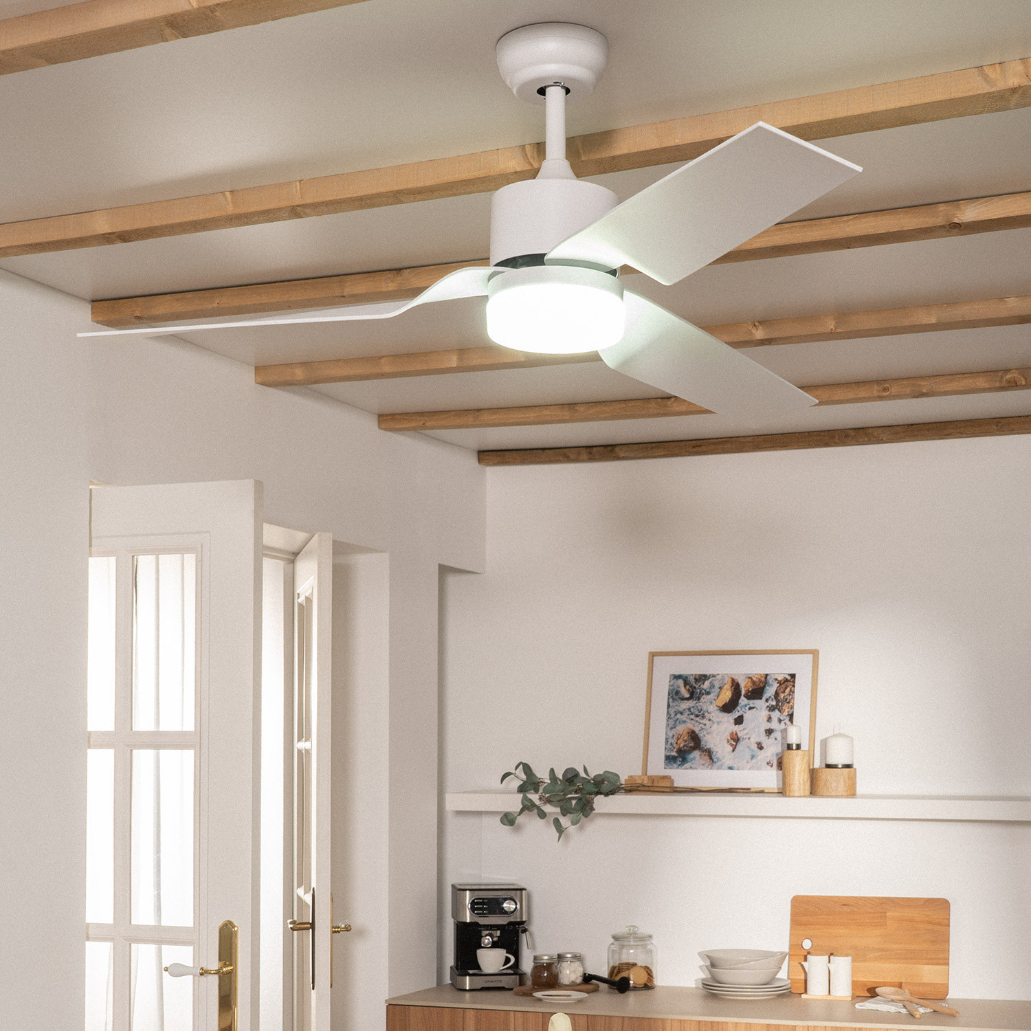 Moderna ventola a soffitto con luce sopra un bancone da cucina con macchina da caffè.