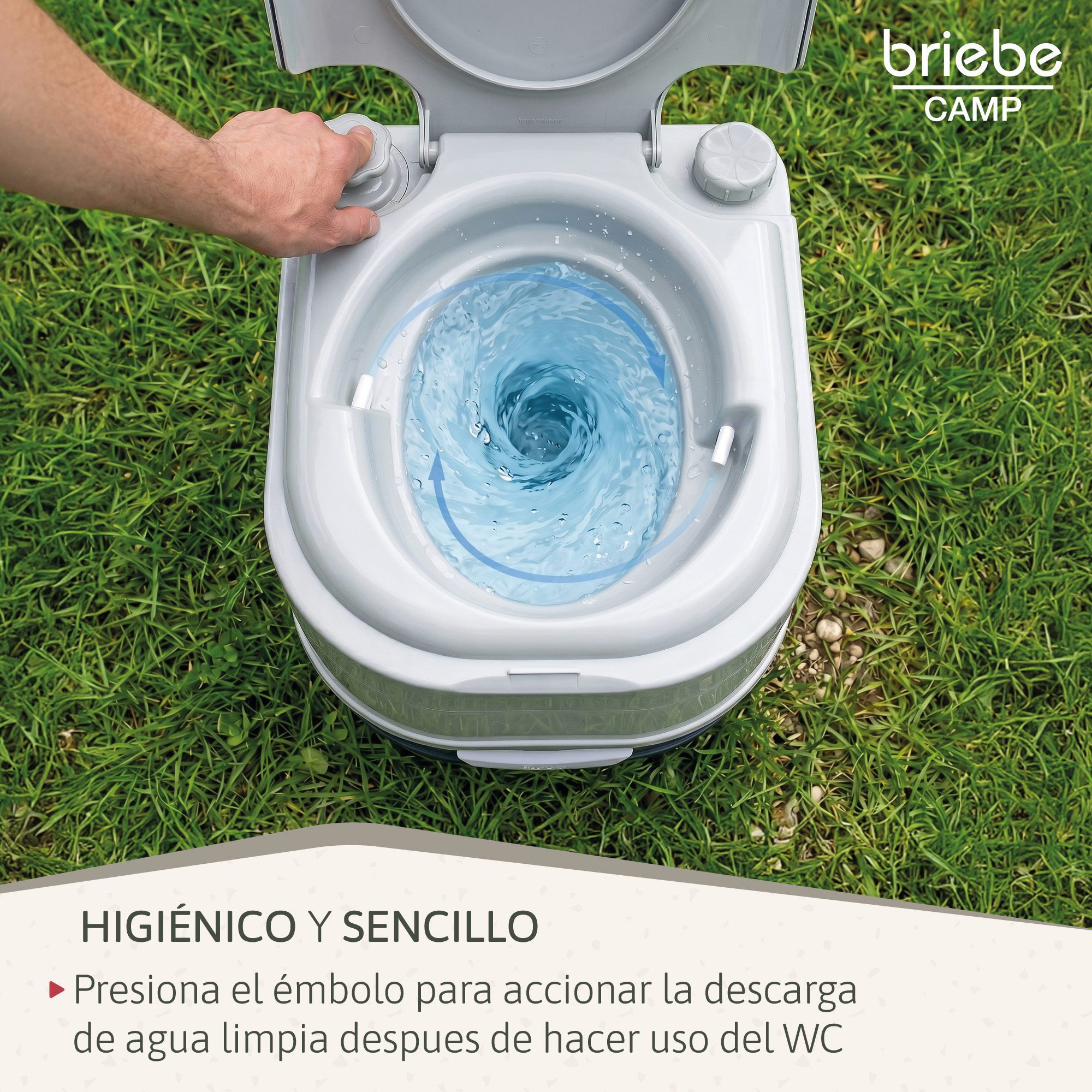 Mano acciona un inodoro portátil con agua arremolinándose en el lavabo sobre hierba.