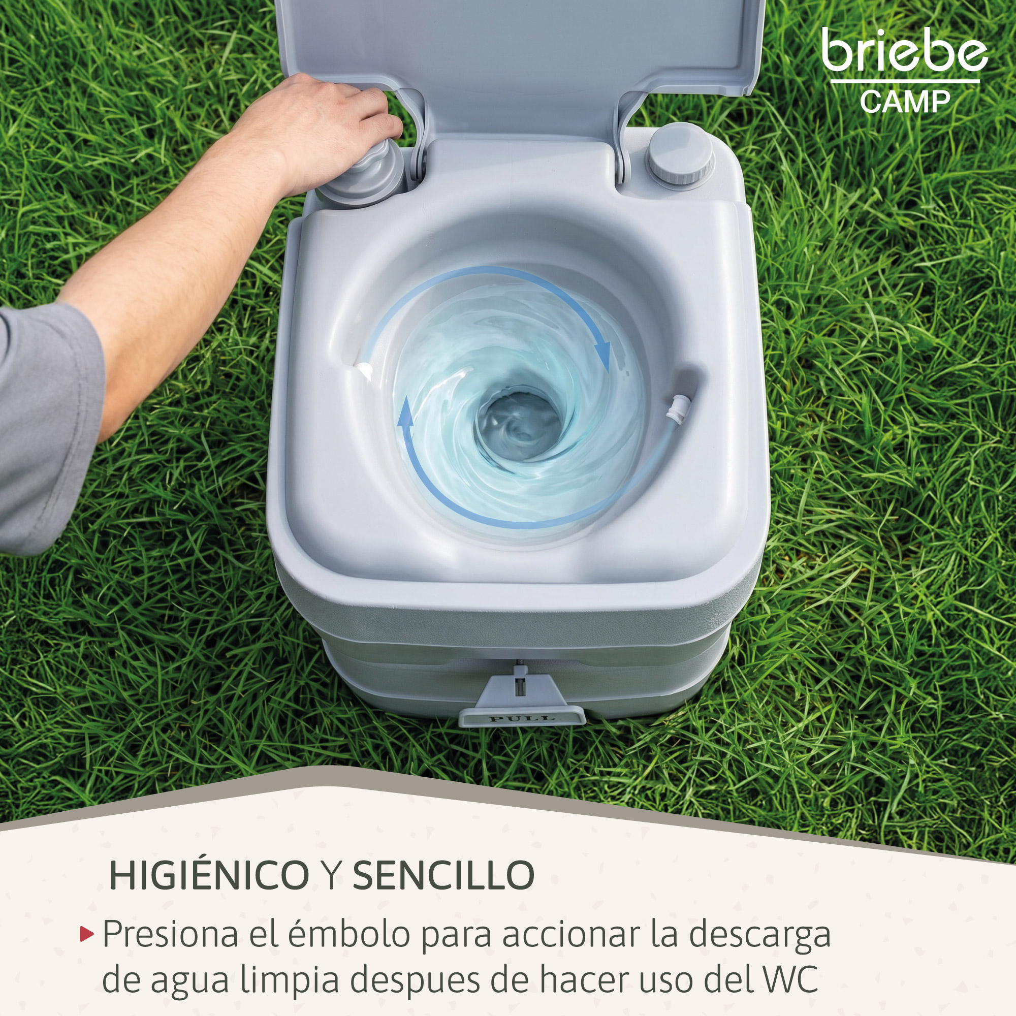 Inodoro portátil gris sobre césped, mano operando la descarga. Agua girando.