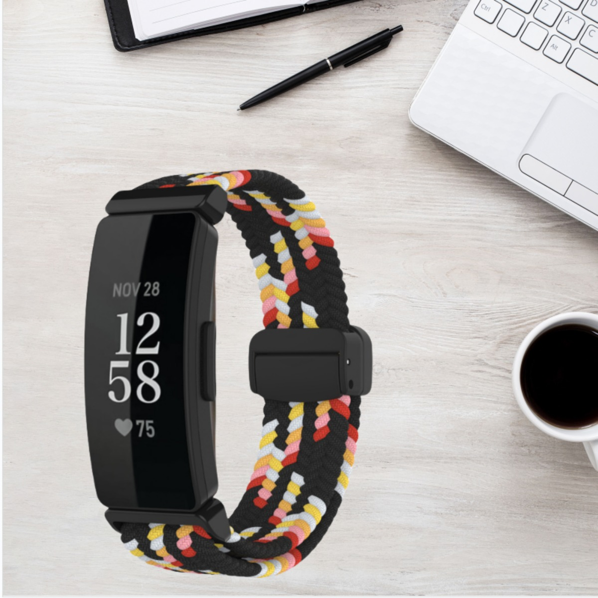Fitness-Tracker mit buntem geflochtenem Armband auf Holzhintergrund.