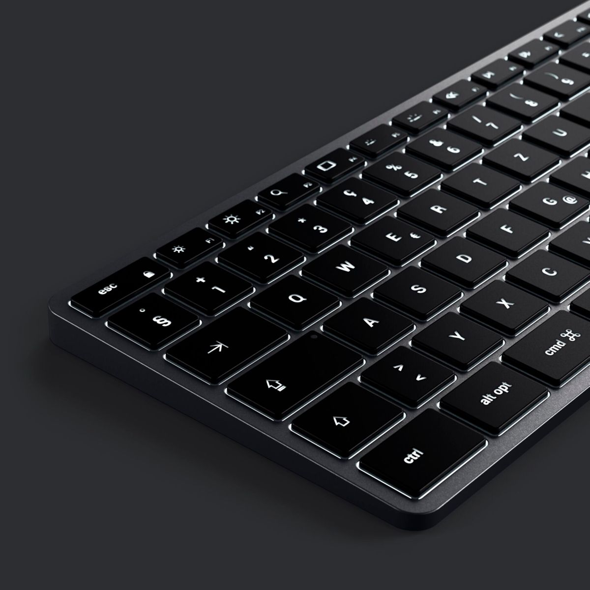 Nahaufnahme, schräge Ansicht einer schwarzen Tastatur mit beleuchteten weißen Tasten vor einem dunkelgrauen Hintergrund.