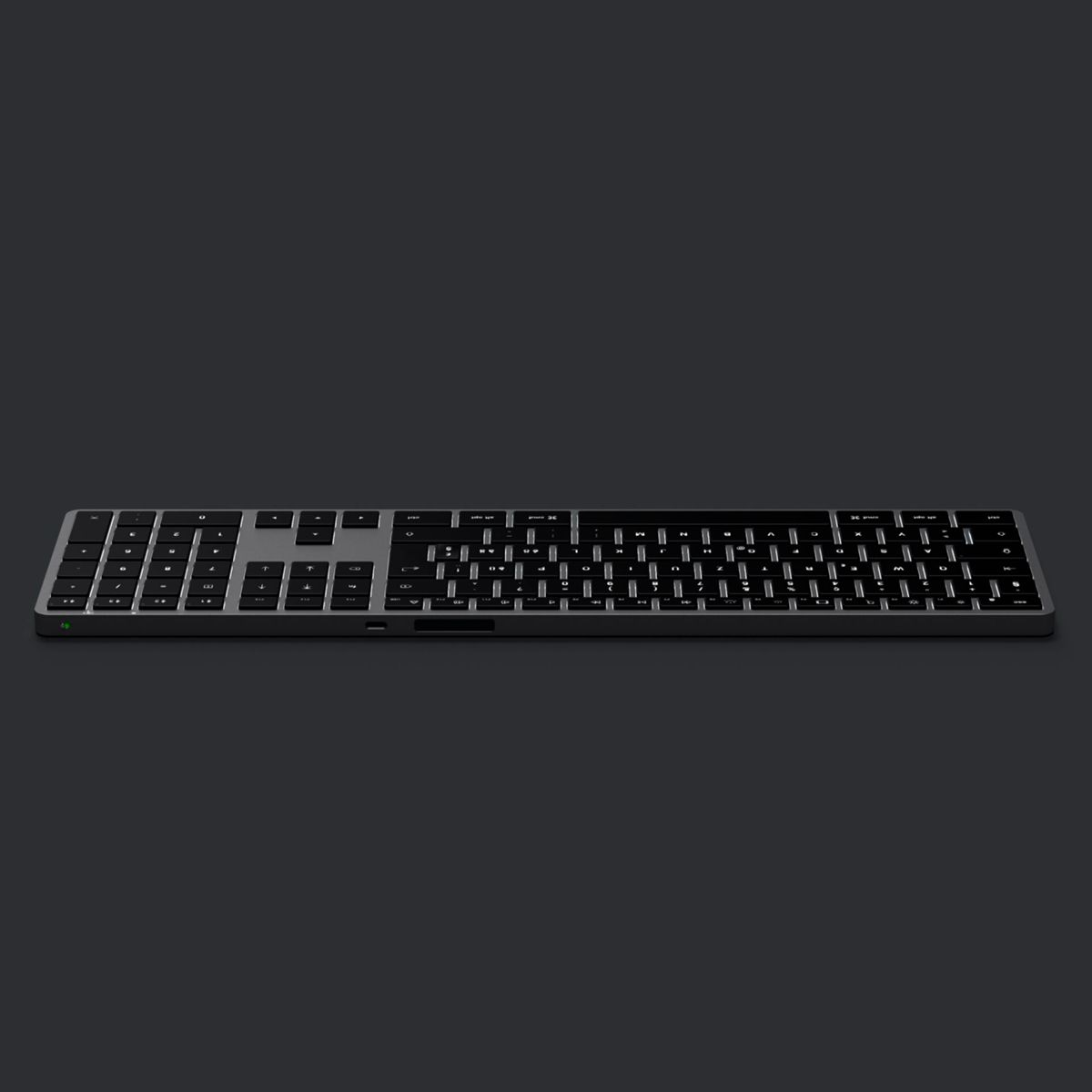 Eine schlanke, silberne kabellose Tastatur mit schwarzen Tasten ist auf einem dunkelgrauen Hintergrund zu sehen.