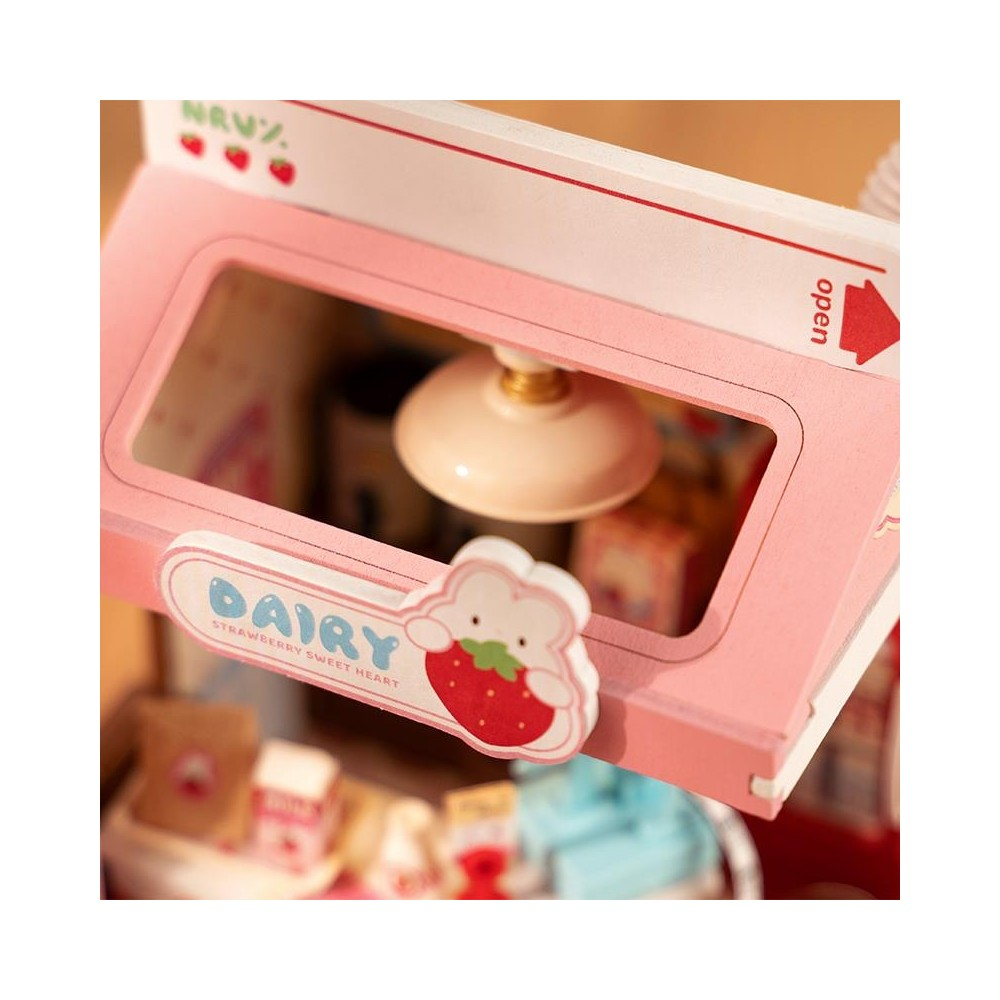 Un negozio di casa delle bambole rosa con insegna "DAIRY" e decorazione fragola.