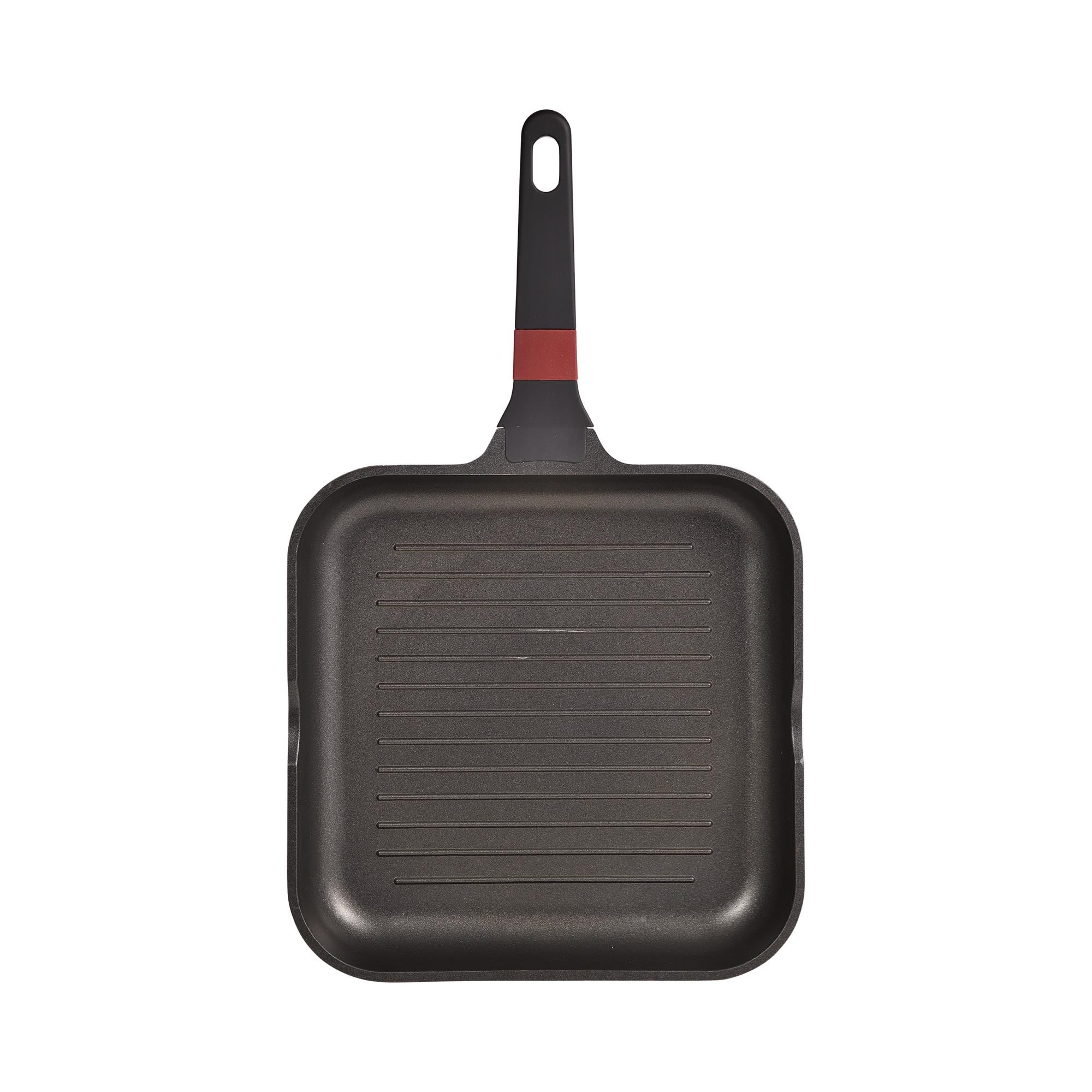 Una sartén grill cuadrada negra con crestas elevadas y mango negro con acento rojo.