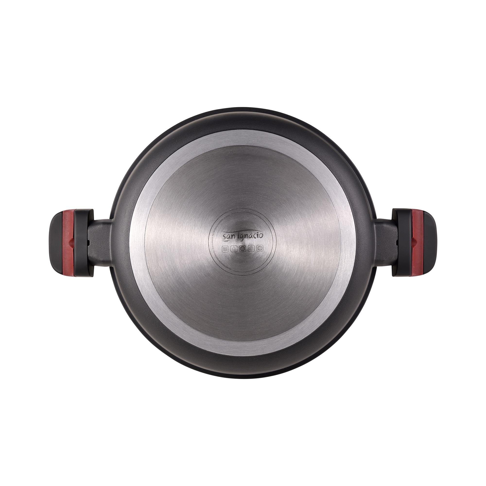 Parte inferior de una olla con base de metal cepillado y asas negras con detalles rojos.